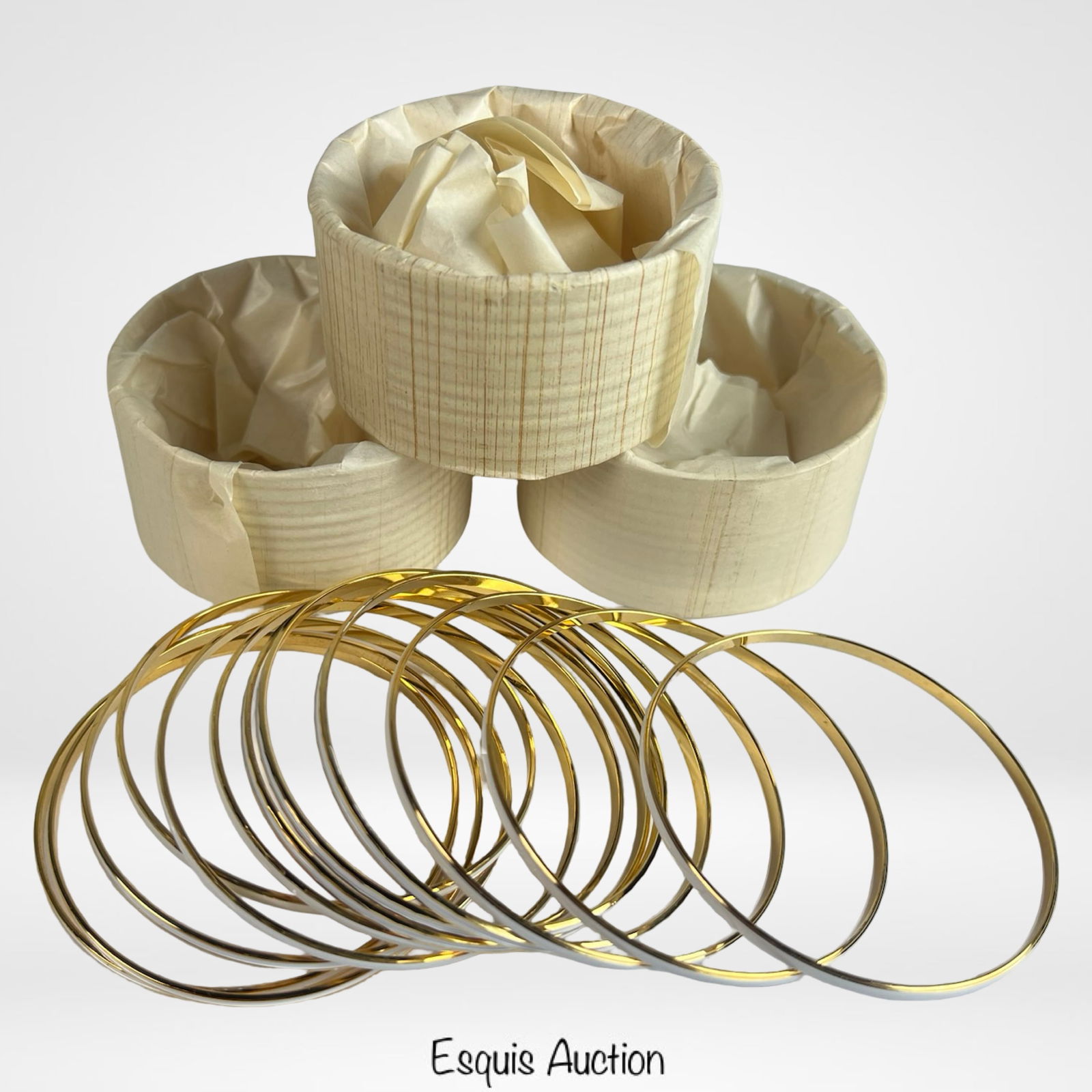 Lot of 48 Gold- and Silver-Tone Bangle Bracelets: Set of four dozen sleek costume jewelry bangles in alternating gold- and silver-tone finishes. Each bracelet features a smooth, minimalist design perfect for stacking or wearing individually. Still in