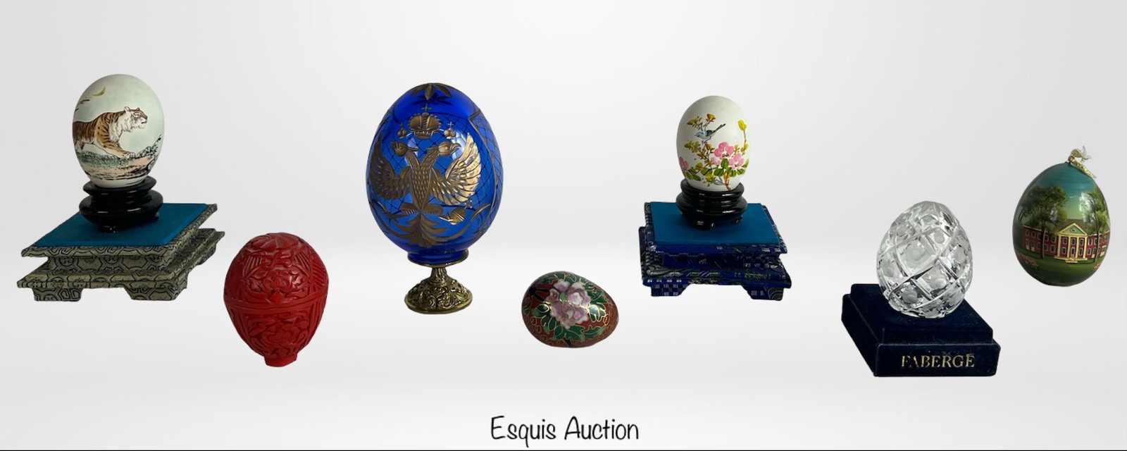 Collection of Decorative Eggs- Faberge, Stone, Han: This eclectic and visually captivating collection features a variety of decorative eggs, ranging in height from 2 to 5 inches. The grouping includes two Faberge eggs: one is a cut crystal egg on a blu
