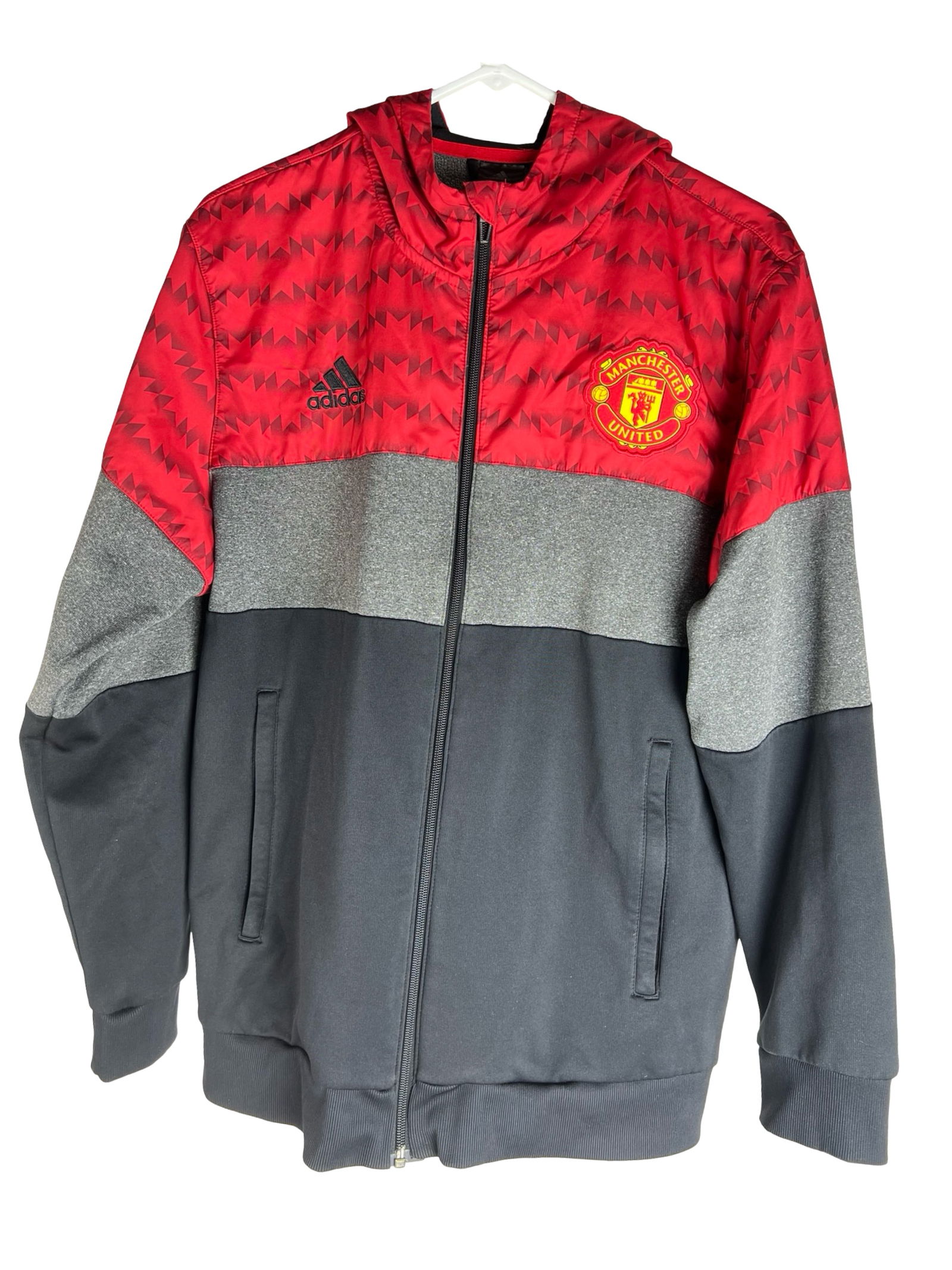 Manchester United Soccer Zip-Up Hoodie Jacket: Channel classic football heritage with this Adidas Manchester United full-zip hoodie featuring a bold red geometric pattern across the shoulders and hood. Constructed with Adidas ClimaWarm fabric, thi