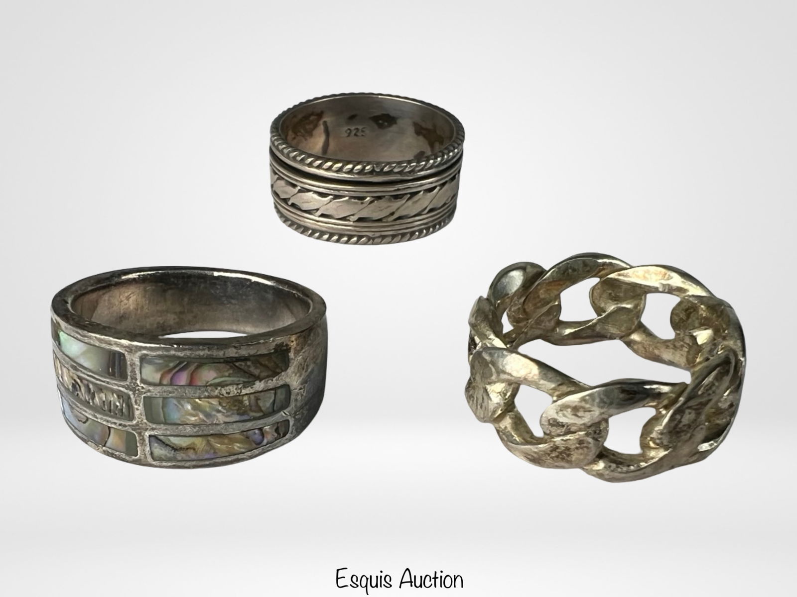 Lot of 3 Sterling Silver Rings: This trio of sterling silver rings showcases a range of styles from intricate to statement-making. One features a textured leaf motif framed with twisted rope edges. Another is crafted in a substantia