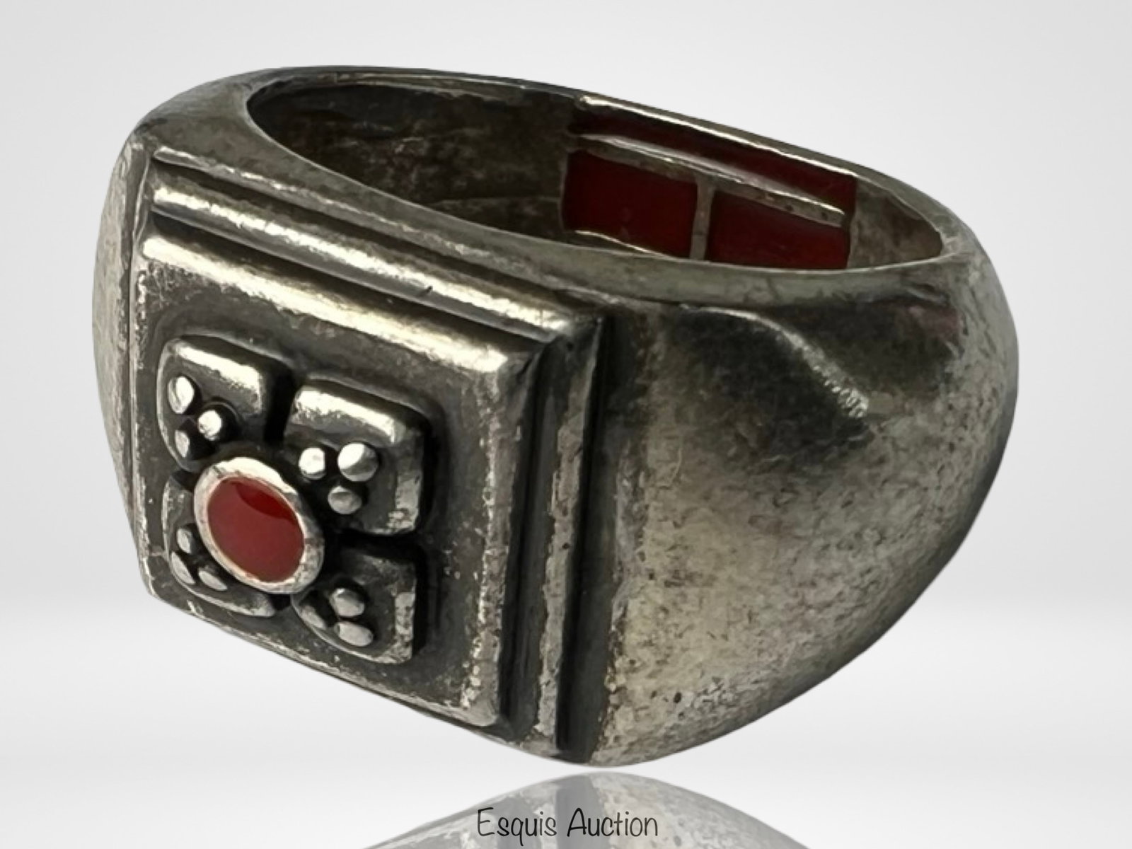 Sterling Silver Renaissance Revival Garnet Ring: Bold and architectural in design, this Renaissance Revival-style ring features a rich garnet cabochon set within a deeply carved cross motif. The thick band has a hammered texture and squared edges fo