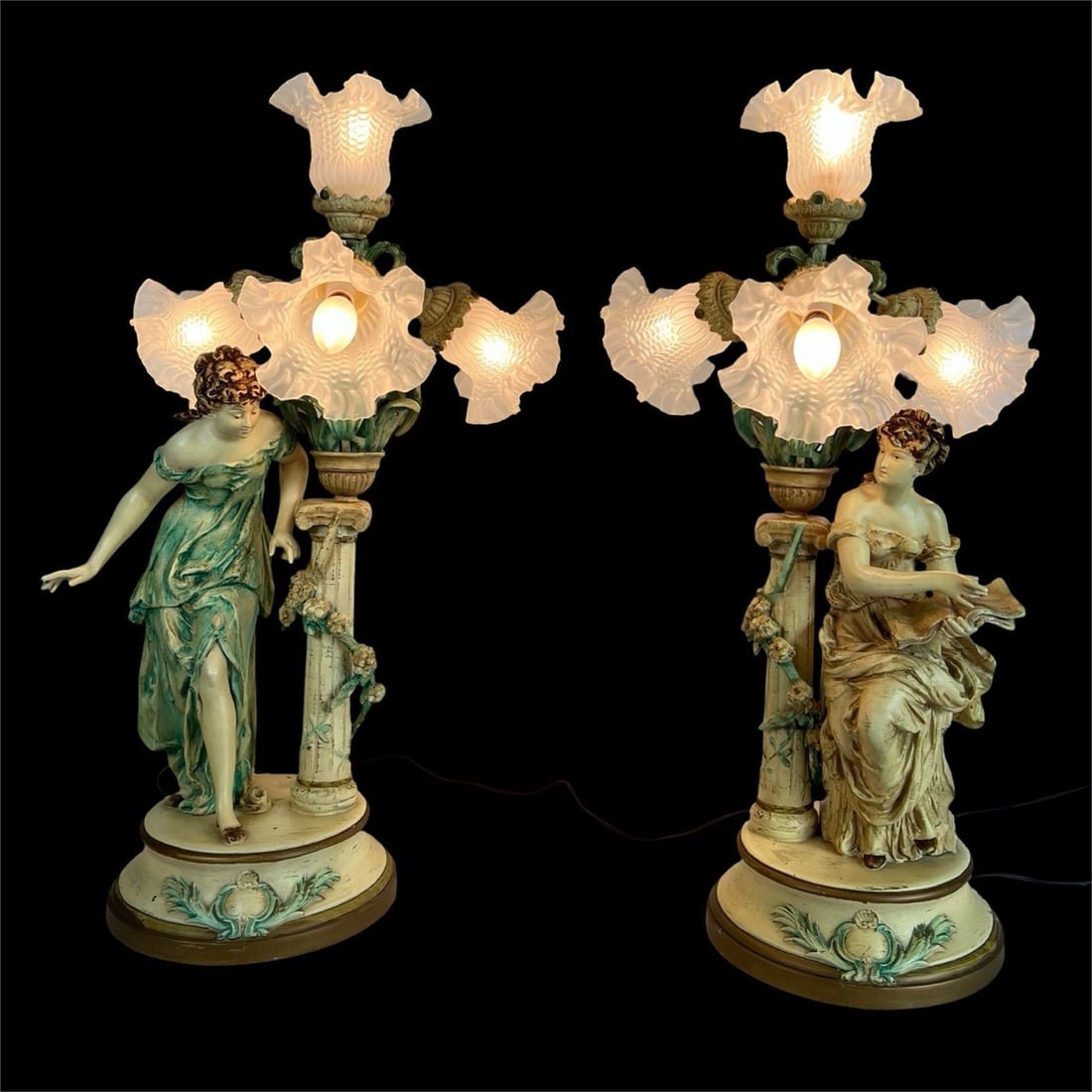 Auguste Moreau- Pair of Art Nouveau Figural Lamps: Elegant pair of Art Nouveau figural lamps after Auguste Moreau, each depicting a classically draped maiden alongside an ornate column entwined with flowering vines. Crafted in spelter with polychrome