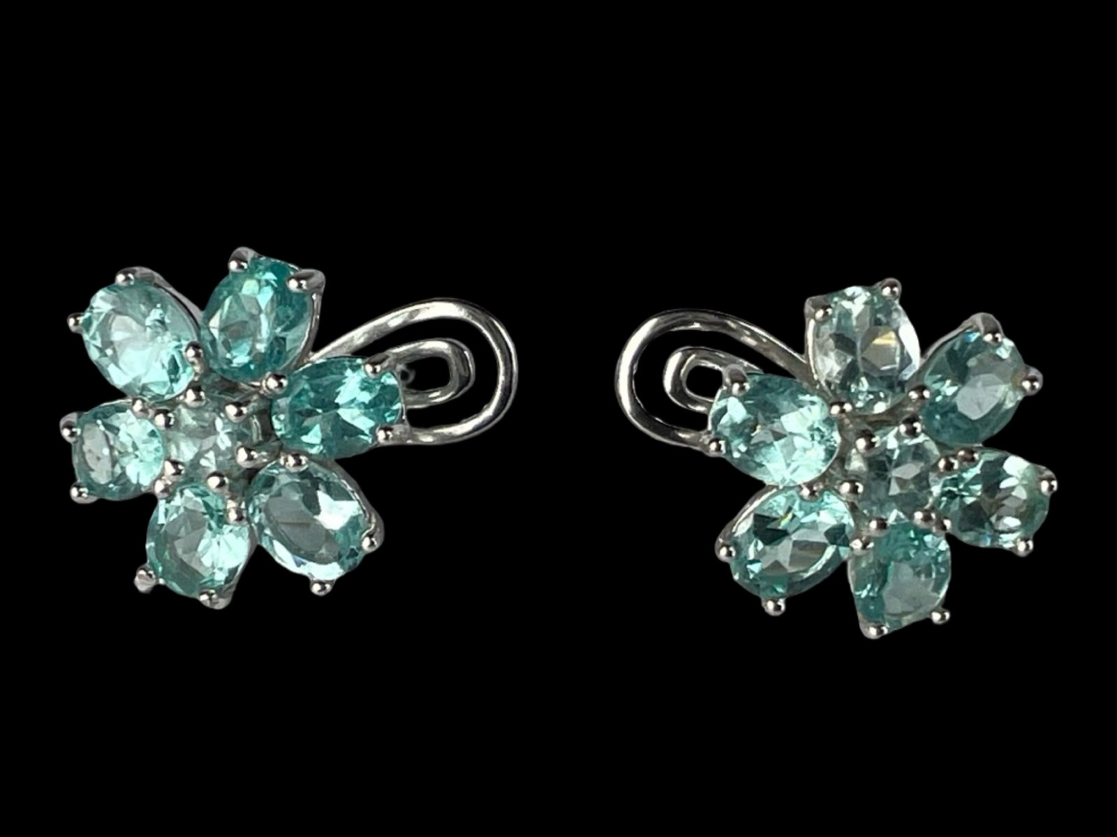 Natural Paraiba Apatite Sterling Silver Earrings: Stunning floral-motif earrings crafted in sterling silver and finished with a 14k white gold plating. Each earring features seven vivid natural Paraiba apatite stones, expertly faceted and arranged in