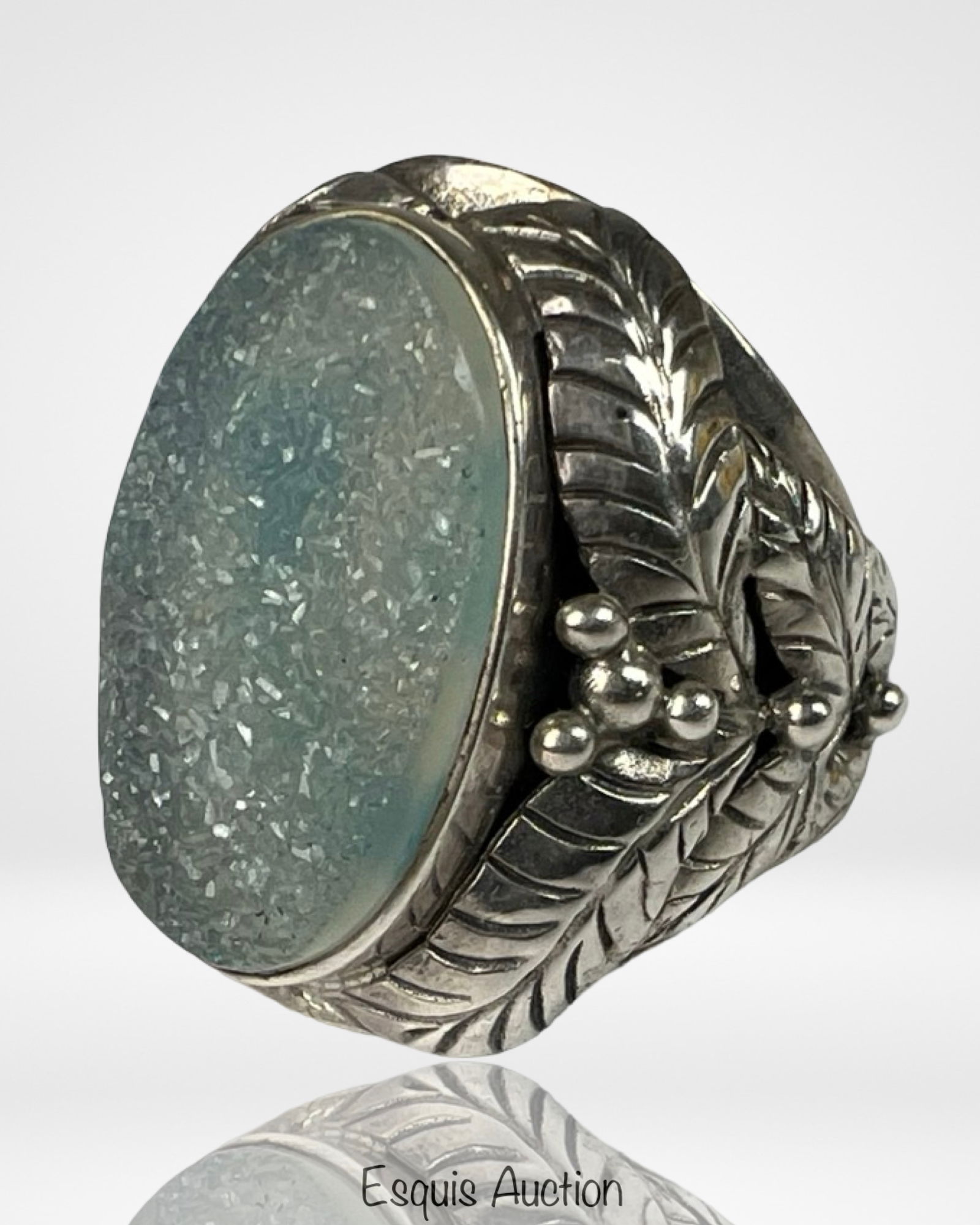 Sterling Silver Ring w/ Textured Aqua Druzy Quartz: This bold sterling silver ring showcases a shimmering aqua blue druzy quartz cabochon with a naturally textured crystal surface that catches light beautifully. The wide band is adorned with intricate