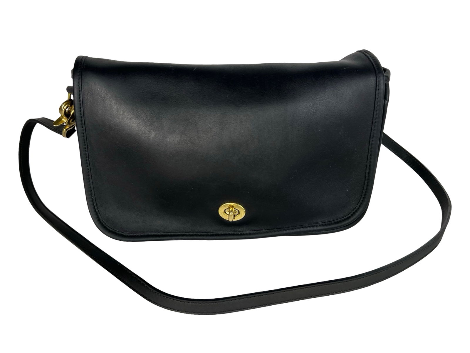 Coach Black Leather Convertible Shoulder Bag: This vintage Coach shoulder bag is crafted from high-quality black leather and features a signature brass turn-lock closure on the flap front. Designed for versatility, it includes a detachable should