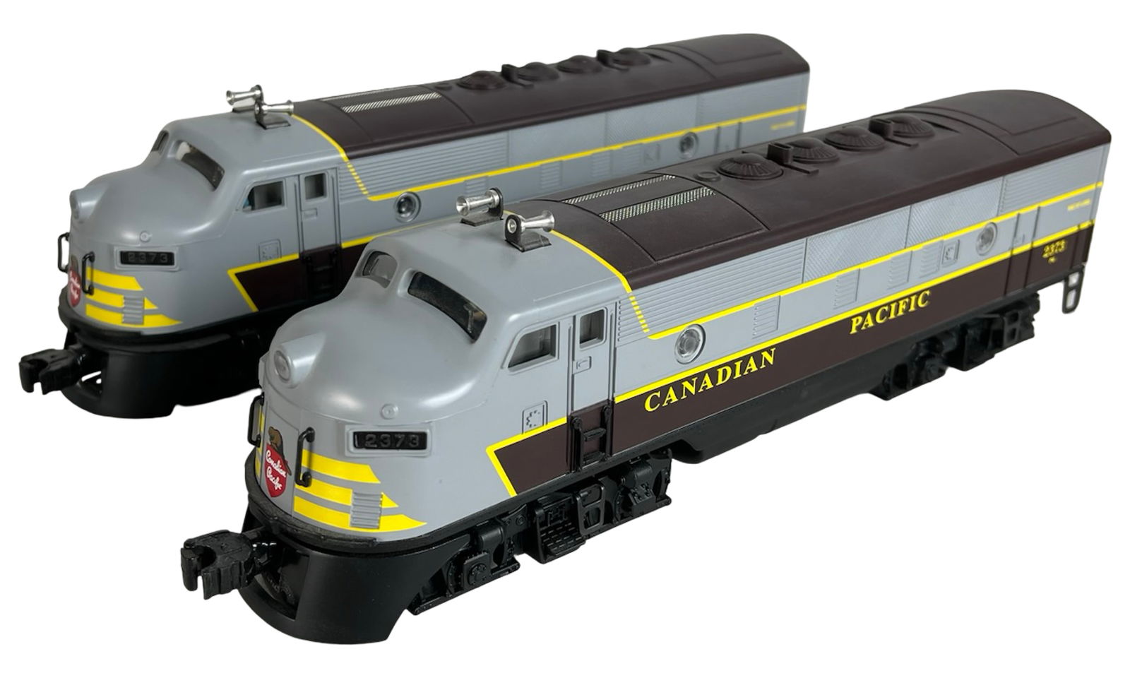Lionel Canadian Pacific F3 Diesel Locomotives: Pair of vintage Lionel Canadian Pacific F3 diesel locomotives, road number 2373, featuring classic gray, maroon, and yellow livery. Both units show clean bodies, detailed grills, and intact horns.
