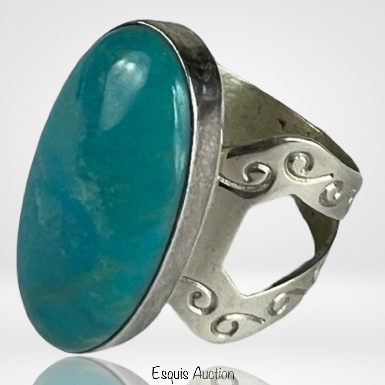 Jay King Kingman Turquoise Statement Ring: Striking oval cabochon of vivid Kingman turquoise set in a polished mount with openwork swirl band. Signed by Jay King, this bold Southwest-style ring offers a clean, sculptural look with natural ston
