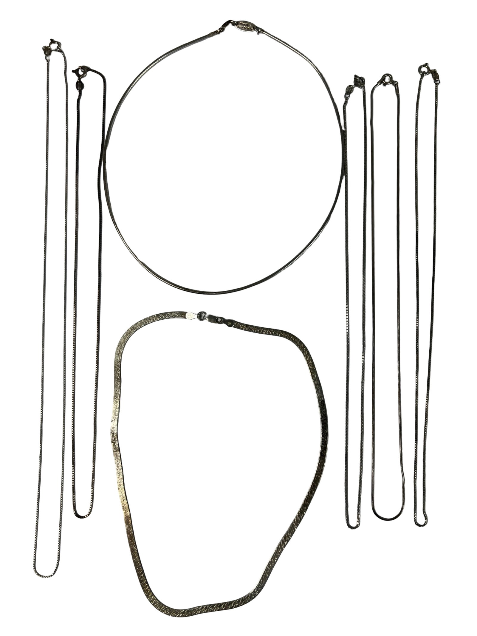 Group of Eight Sterling Silver Necklaces: Collection of eight sterling silver necklaces, featuring a mix of box chains, herringbone styles, and a rigid omega-style collar. Includes one marked Paolo Romeo. Lengths range approximately from 16" 
