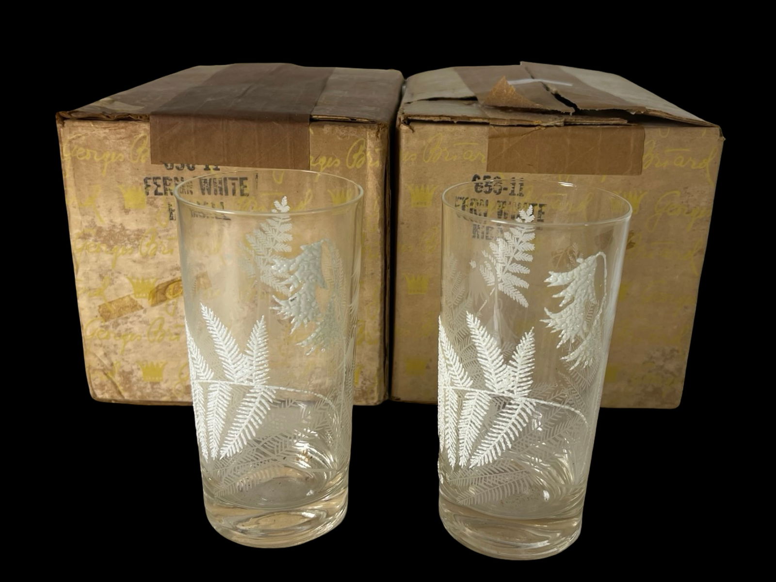 MCM Georges Briard Fern White Highball Glasses: Set of 12 unused Georges Briard highball glasses with a delicate white fern and flower motif, still packed in two original boxes from Marshall Field's. Each glass measures approximately 5 1/2" to 6" t