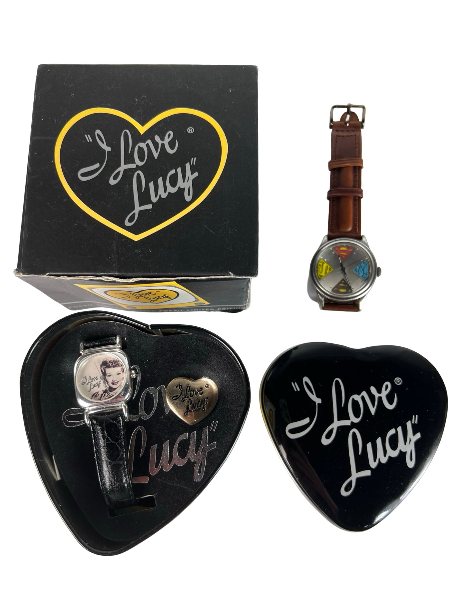 Fossil "I Love Lucy" & "Superman" Wrist Watches: Charming Fossil collectible "I Love Lucy" wristwatch presented in its original black heart-shaped tin with logo and matching outer box. The watch features a portrait of Lucille Ball and includes a gol