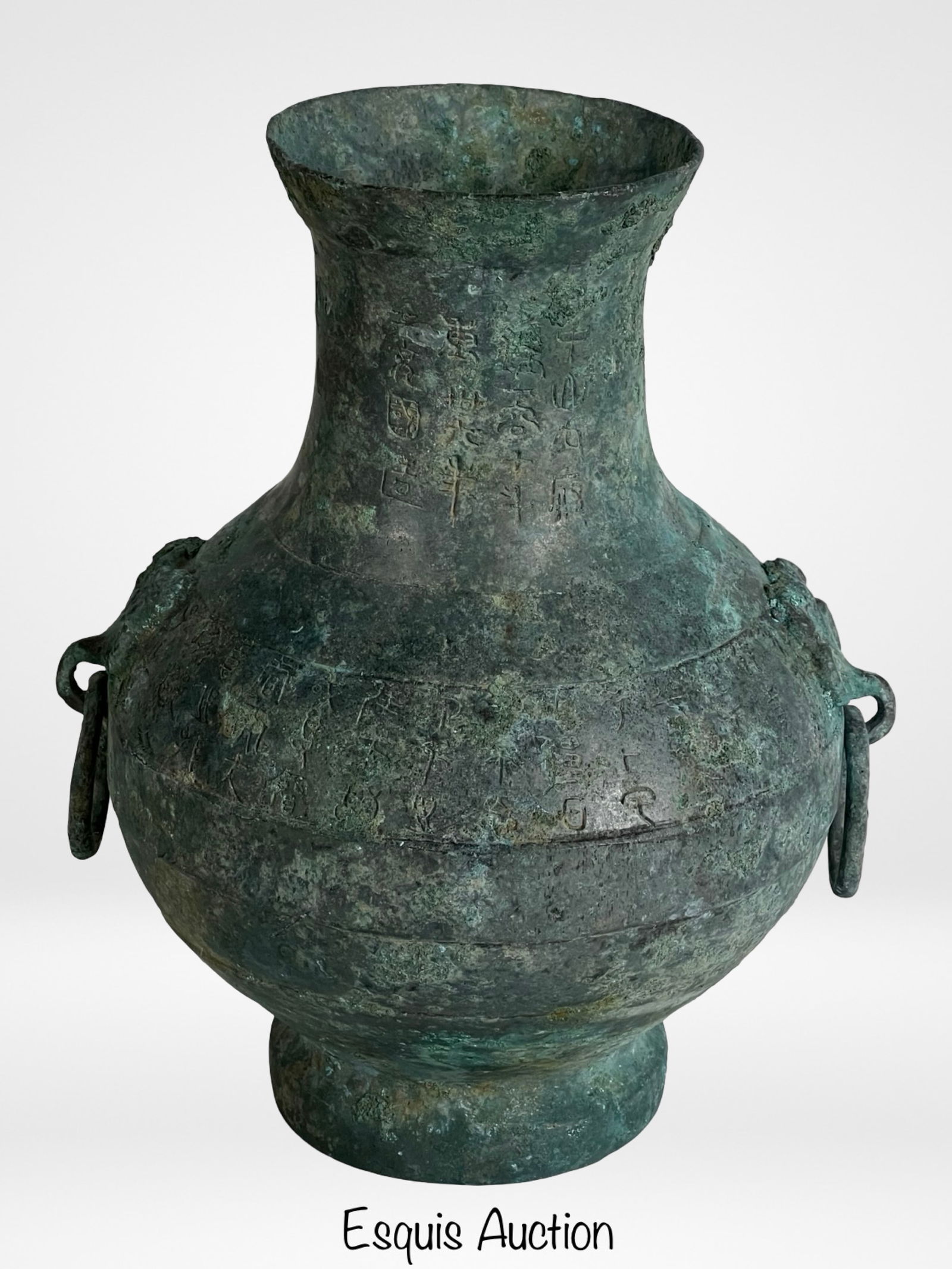 Antique Chinese Archaic Bronze Hu Vessel: A finely cast antique Chinese bronze Hu-form vessel featuring a graceful flared neck, globular body, and raised foot. The surface displays a rich green patina from age and burial, with two stylized