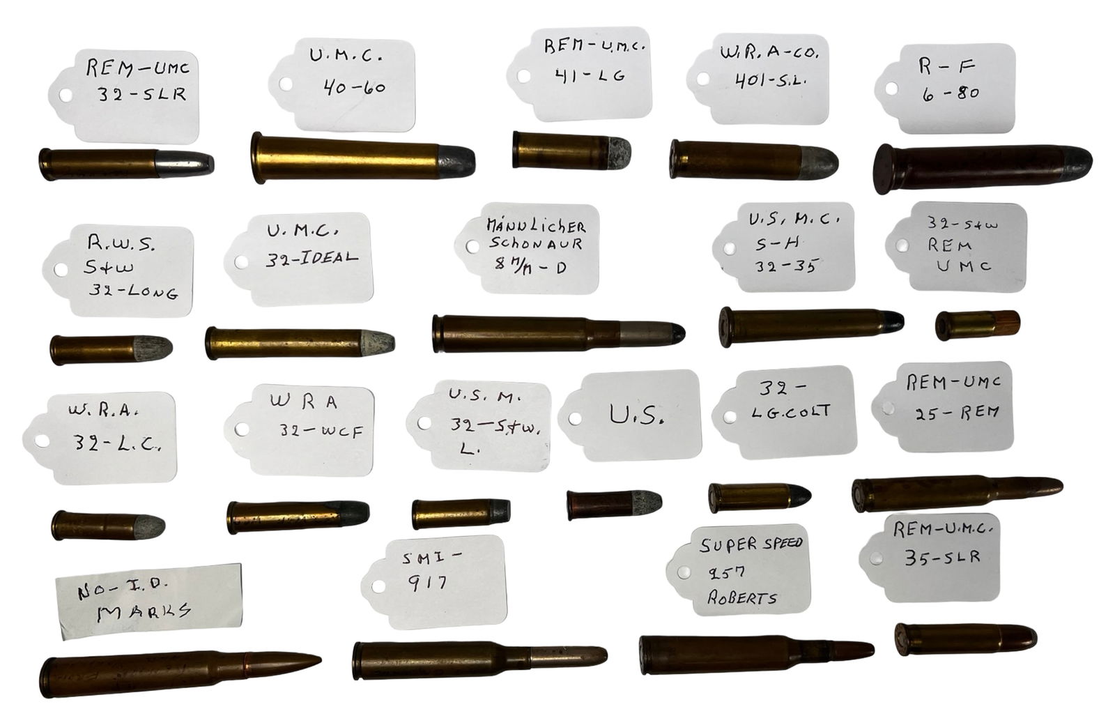 Group of Antique & Vintage Ammunition Cartridges: Diverse collection of antique and vintage cartridges ranging from the late 19th century to the WWII era, each accompanied by a handwritten ID tag. The calibers and manufacturers vary widely, with