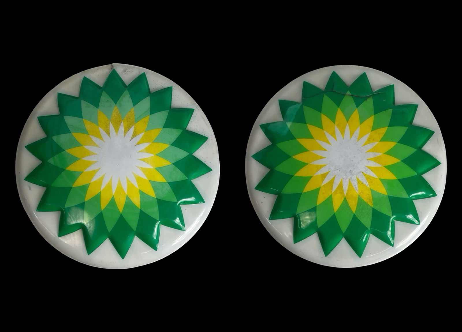 BP Gas Station Round Logo Sign Covers: Lot of two large round BP gas station logo sign covers featuring the iconic green and yellow sunflower design. Both examples measure approximately 28 inches in diameter.These sign faces are in as-foun