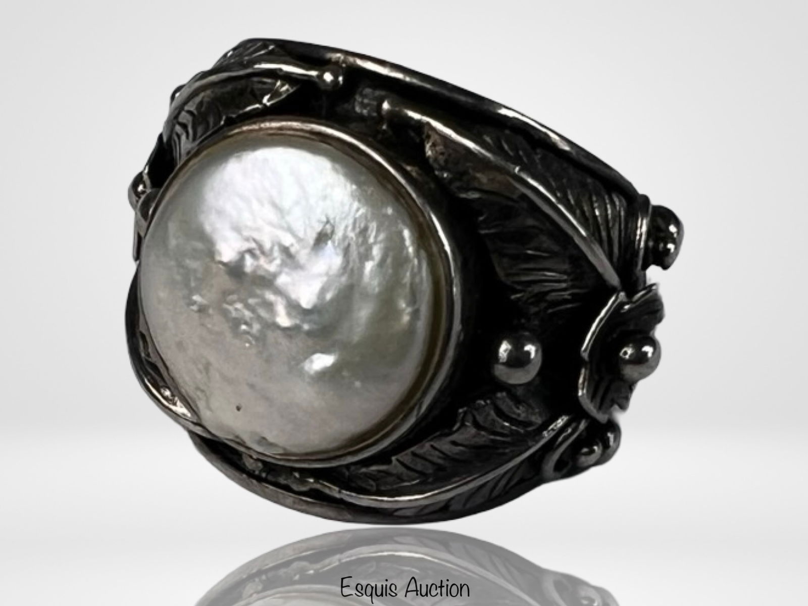 Sterling Silver Ring with Mother-of-Pearl Cabochon: Striking sterling silver ring set with a large domed mother-of-pearl cabochon displaying luminous silvery iridescence and natural nacre striations. The stone is framed by a bold, sculptural silver set