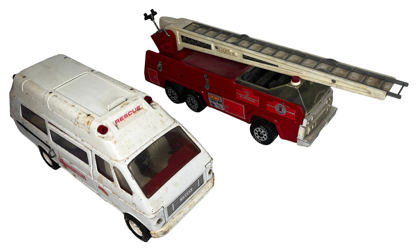 Vintage Tonka Fire Truck and Rescue Ambulance: This lot features two classic pressed steel emergency vehicles by Tonka, each showing signs of age and heavy play. The red fire truck is marked "City of Blazedale Fire Rescue - Aerial Unit 2" and incl