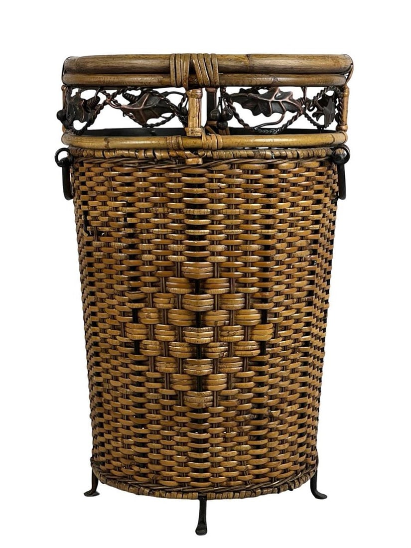 Vintage Woven Basket with Decorative Metal Accents: This tall vintage woven basket showcases fine craftsmanship with tightly woven natural fibers forming a sturdy cylindrical body. The upper rim is adorned with decorative metalwork featuring leaf and