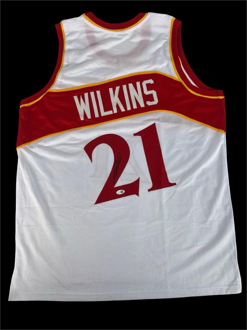 Dominique Wilkins Autographed Atlanta Hawks Jersey: Autographed Dominique Wilkins Atlanta Hawks jersey featuring his iconic #21. The signature appears clearly on the back numeral and includes JSA authentication for added assurance. Vibrant team colors