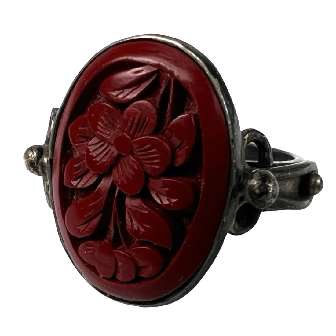 Sterling Silver Carved Red Cinnabar Floral Ring: Elegant vintage sterling silver ring featuring a detailed hand-carved red cinnabar centerpiece with an intricate floral motif. The oval cinnabar carving is set in a bezel with decorative silverwork al