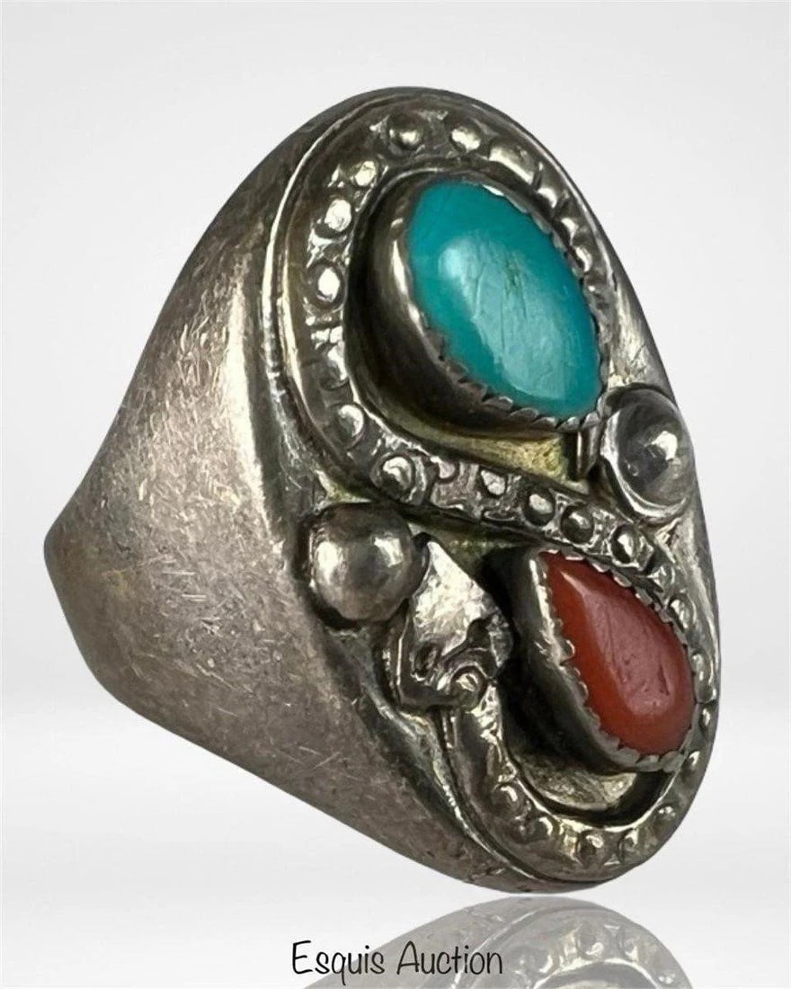 Navajo Turquoise & Coral Sterling Silver Ring: Massive handmade Navajo ring featuring bezel-set turquoise and red coral stones in a striking, shield-shaped setting. The bold design is accented with detailed applied silverwork and displays a strong
