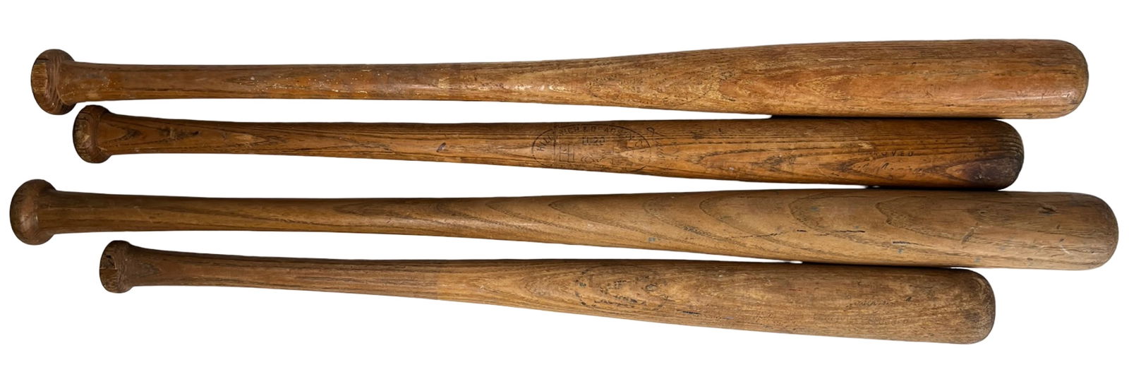 Four Vintage Wooden Baseball Bats: Group of four vintage wooden baseball bats showing heavy game use and natural age wear throughout. The bats display darkened patina, surface scuffs, rack marks, finish loss, and handling wear