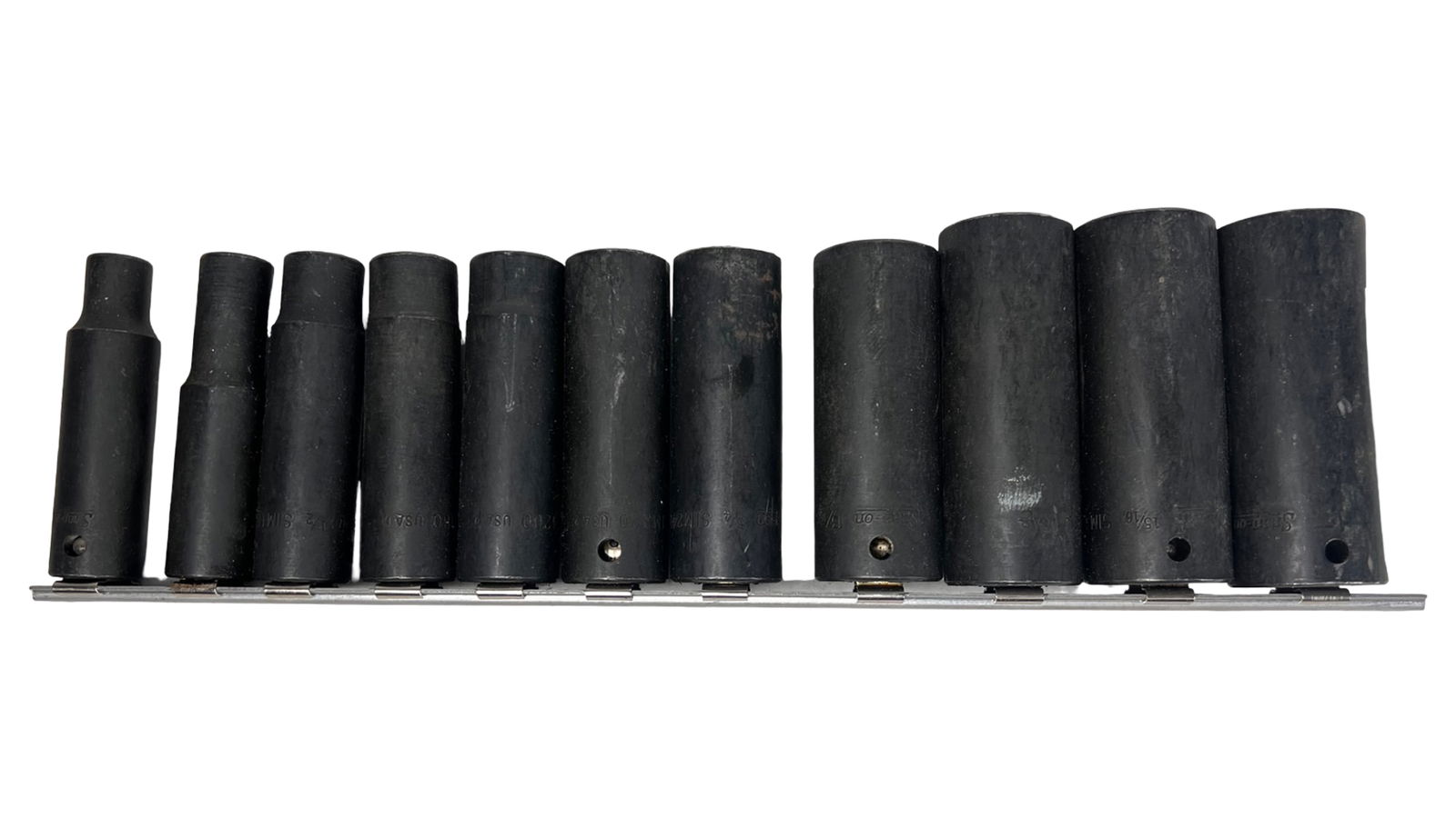 Snap-On Drive Impact Socket Set: Professional-grade Snap-On drive impact socket set featuring a group of heavy-duty black oxide sockets mounted on a metal storage rail. These industrial-strength sockets are designed for use with
