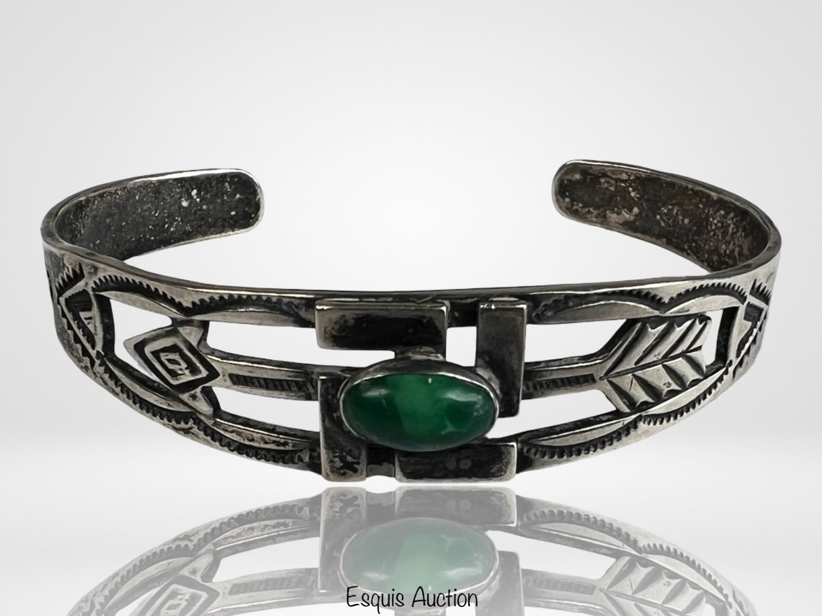 Sterling Silver Good Fortune Cuff Bracelet: Sterling silver cuff bracelet featuring a raised central good fortune symbol set within a bold geometric frame. The band is accented with engraved and oxidized motifs including arrows, leaf elements,