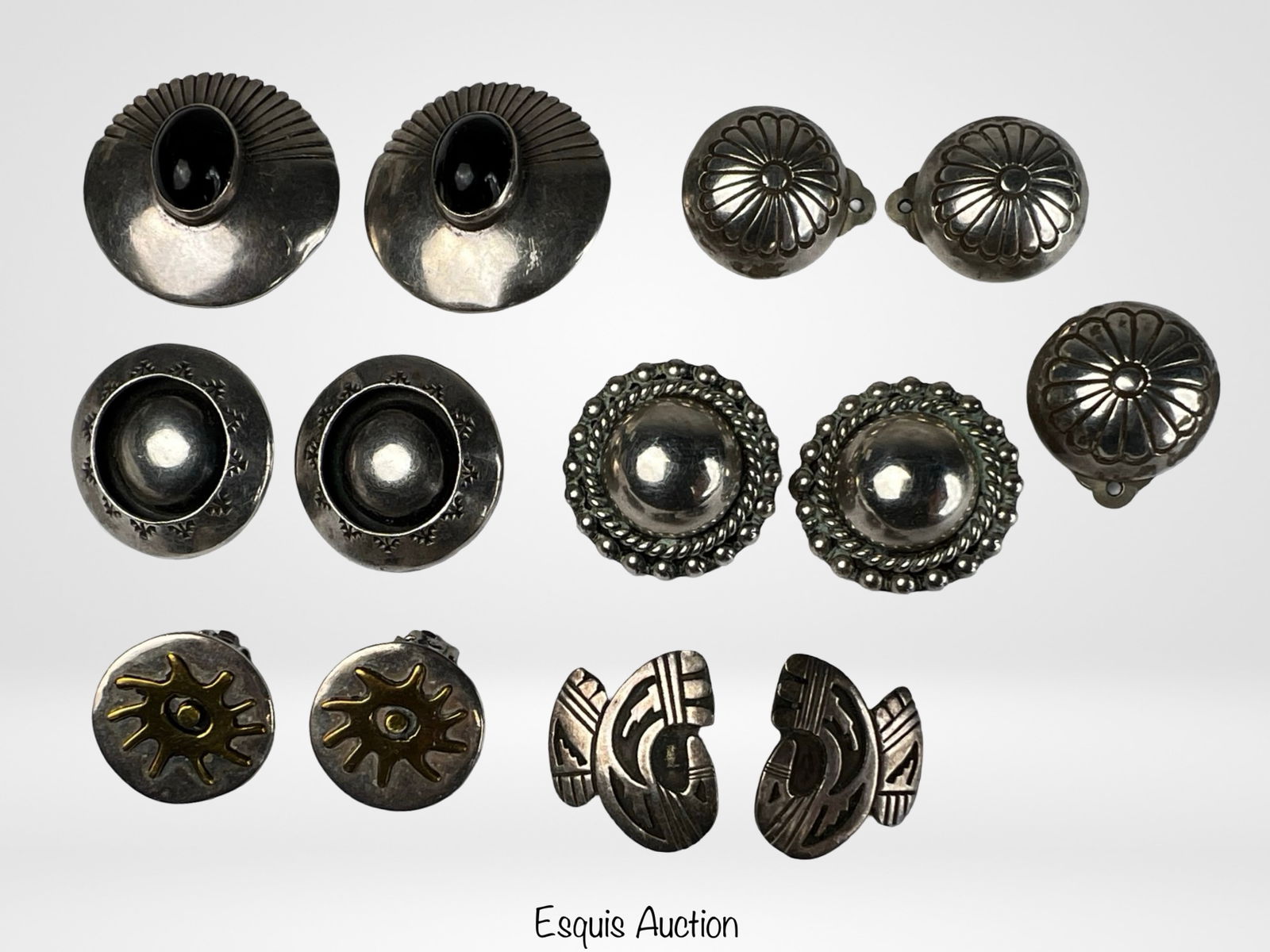 Assortment of Vintage Sterling Silver Earrings: Group of vintage sterling silver clip-on earrings featuring a variety of classic and Southwestern-inspired designs. Styles include domed and scalloped forms, rope-edge detailing, engraved accents,