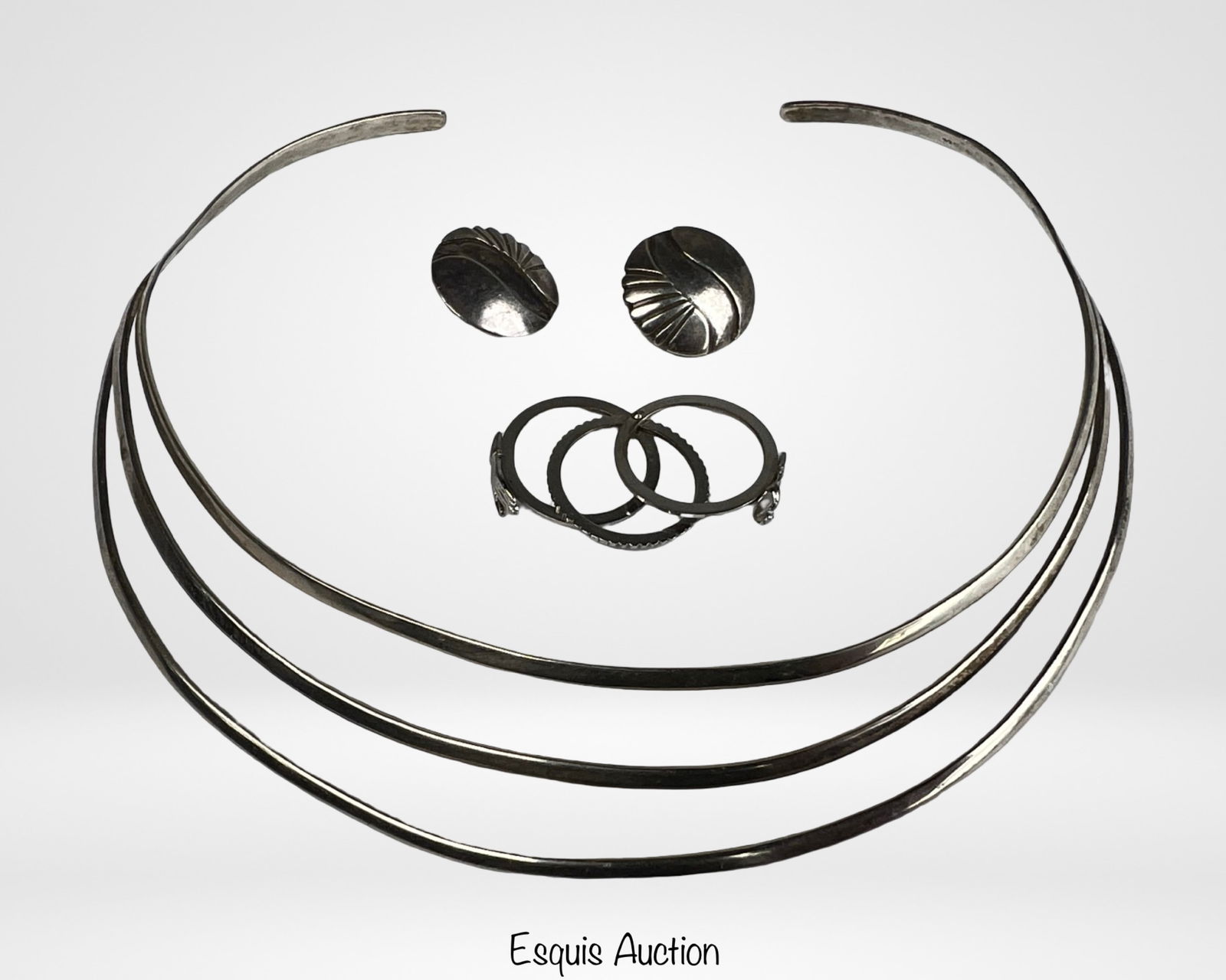 Sterling Silver Modernist Jewelry Set: Contemporary sterling silver jewelry set featuring a sleek triple-band collar necklace measuring approximately 5.5" x 5", a coordinating ring (size 6), and a matching pair of sculptural earrings. The