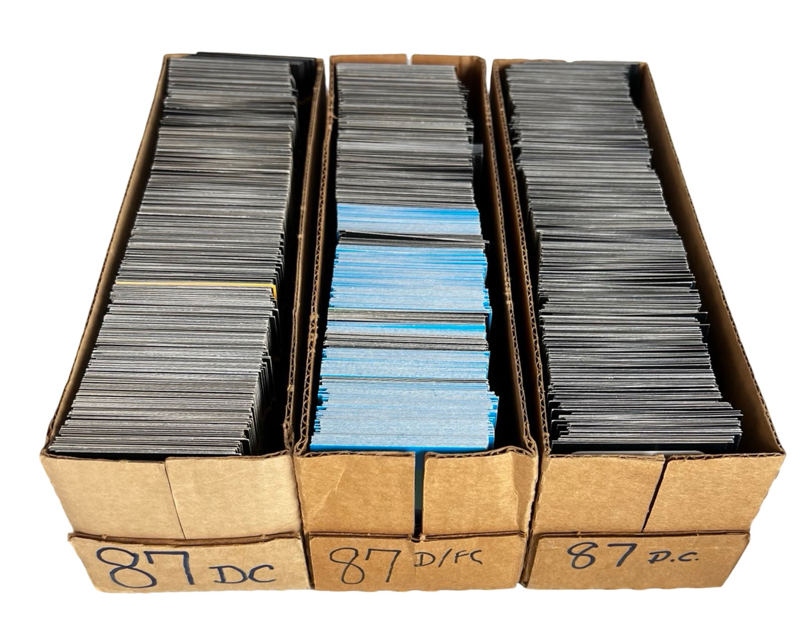 Three-Row Box Filled with Vintage Baseball Cards: Substantial assortment of vintage baseball cards housed in three long storage boxes. The boxes are densely packed and appear to contain a large quantity of cards from the late 1980s era and possibly