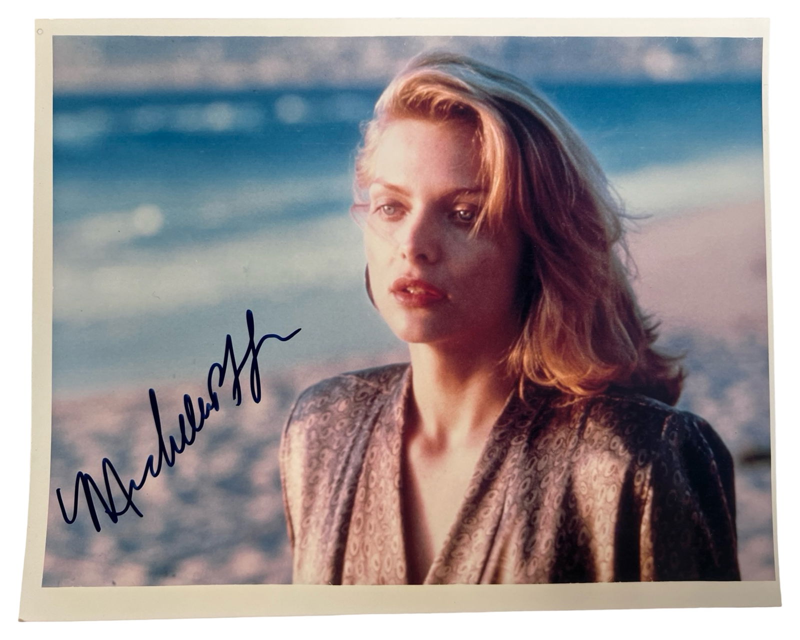 Michelle Pfeiffer Signed Tequila Sunrise Photo: Color photograph from the 1988 film Tequila Sunrise, boldly signed by Michelle Pfeiffer in blue marker. The image captures Pfeiffer in one of her most recognizable late-1980s roles, posed against a