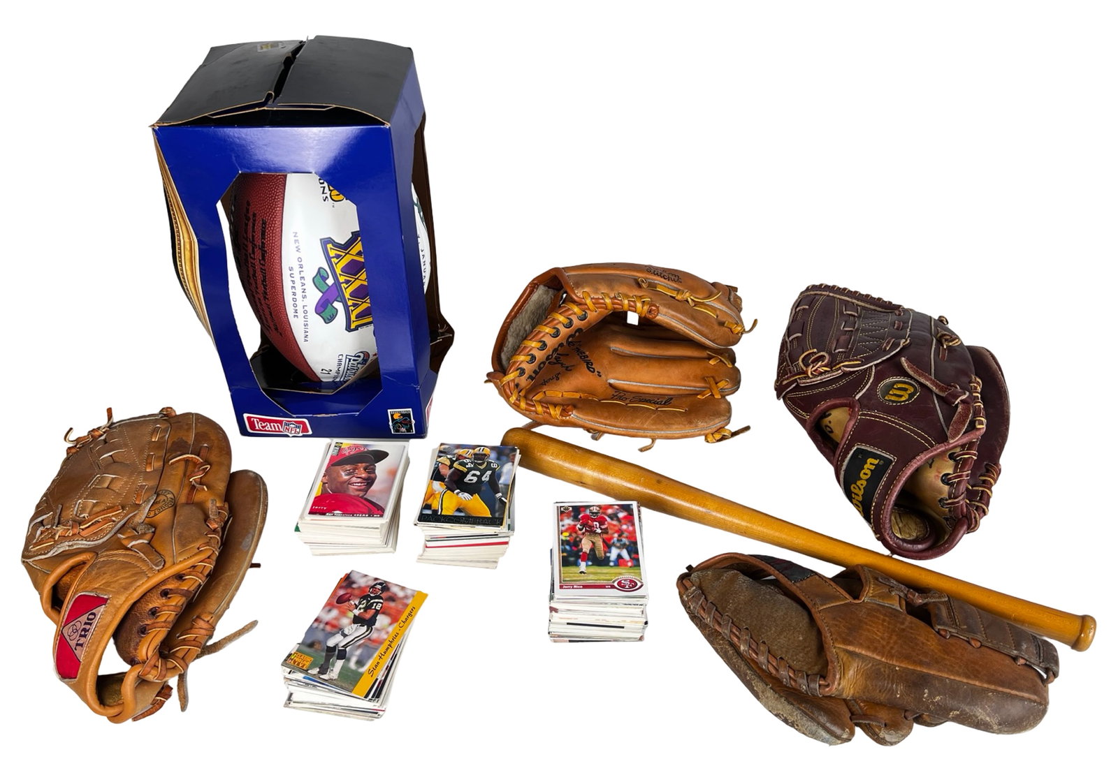 Ecleric Sport Memorabilia Lot: Eclectic sports memorabilia lot featuring vintage baseball equipment, commemorative football, and stacks of trading cards.Included are multiple leather baseball gloves in varying ages and conditions,