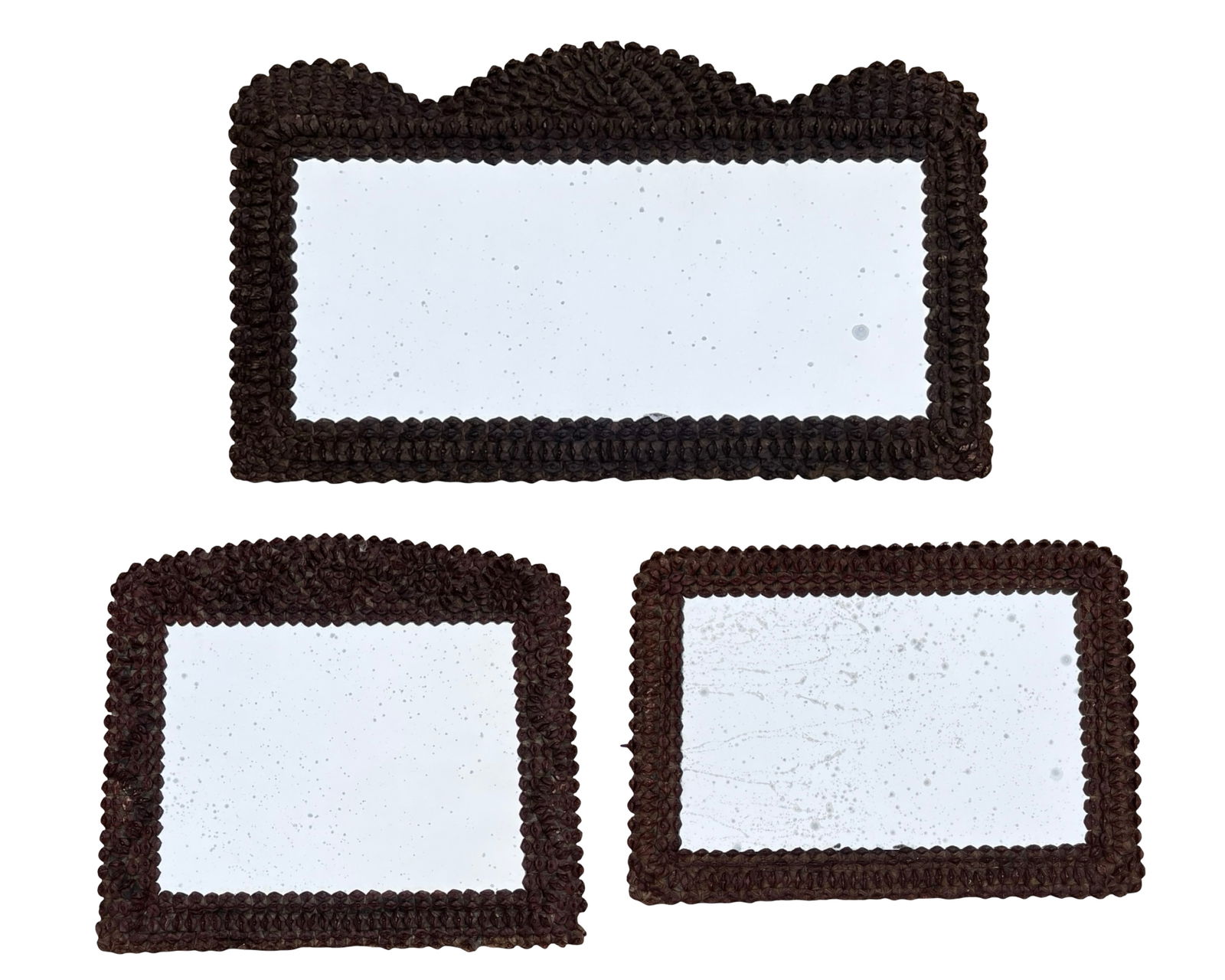 Antique Tramp Folk Art Carved Wooden Mirrors: Set of three antique tramp art wall mirrors with hand-carved layered wooden frames created in the traditional chip-carved folk art technique. The largest example features a decorative scalloped