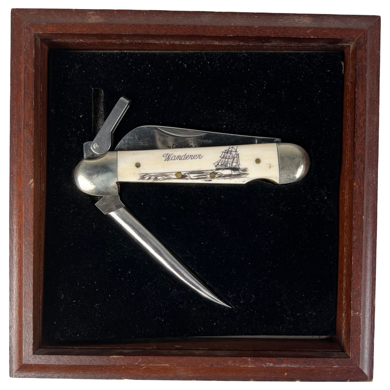 Mammoth Bone Scrimshaw Folding Knife "Wanderer": Scrimshaw-style folding knife from the Collector's Series titled "Wanderer." The handle is crafted from mammoth bone and features engraved maritime imagery including a sailing ship and coastal scene.