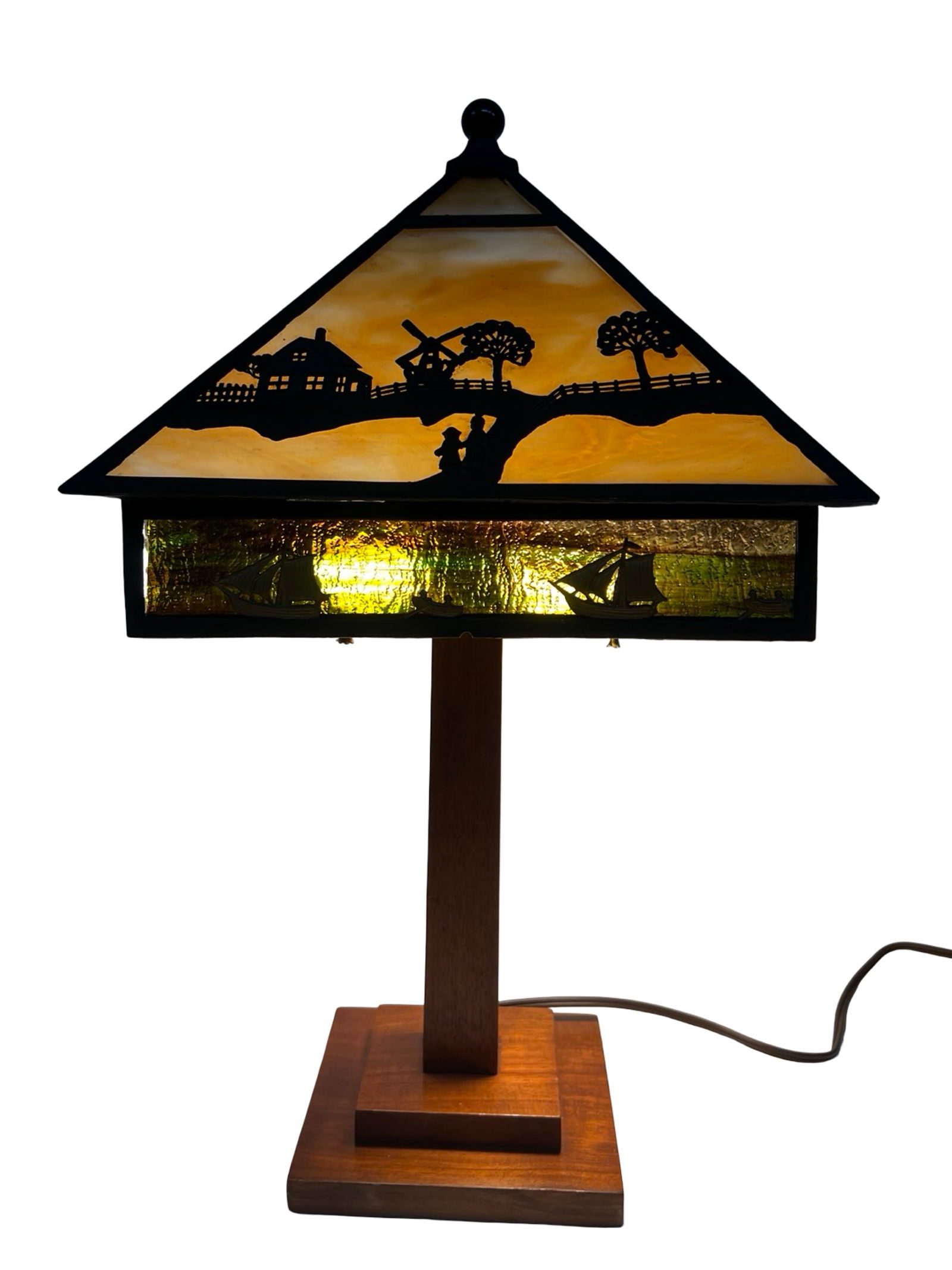Antique Dutch Farm Scene Stained Glass Table Lamp: Charming antique stained glass table lamp featuring a picturesque Dutch countryside farm scene. The shade is decorated with silhouetted metal figures depicting a farmhouse, windmill, trees, fencing,
