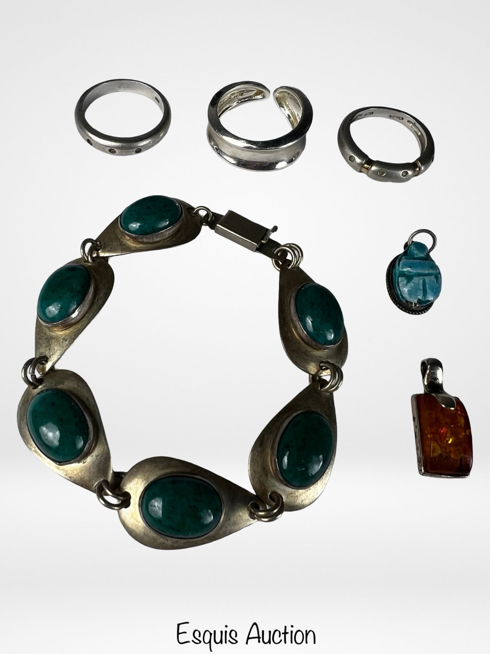 Sterling Silver Jewelry- Bracelet, Rings, Pendants: Group of sterling silver jewelry including a link bracelet set with oval green cabochon stones, three sterling silver rings, and two pendants. Bracelet length: 7". Ring sizes: 7.5, 8, and 8.5.