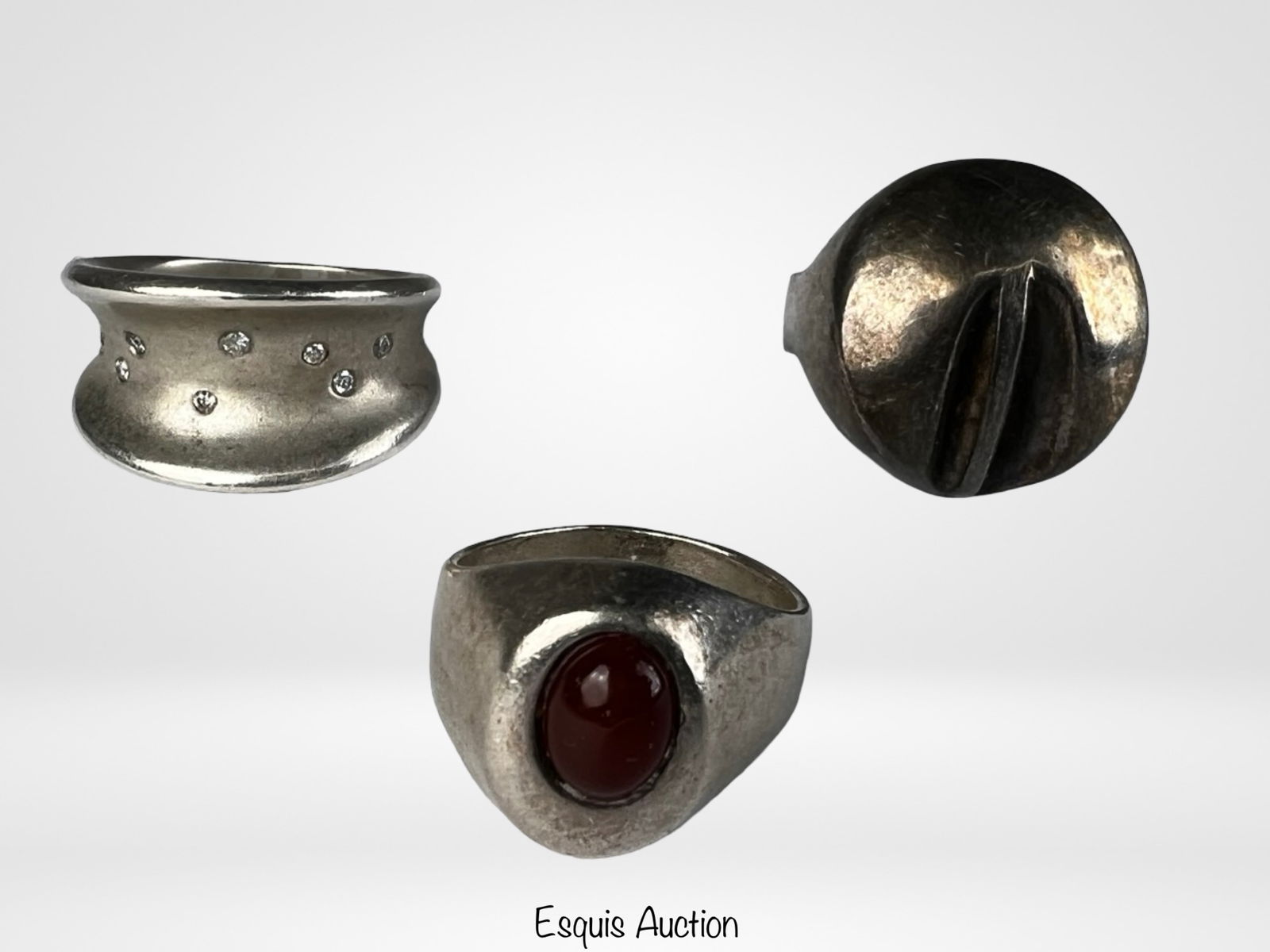 Sterling Silver Ladies Ring Group- Red Cabochon: Group of three sterling silver ladies rings featuring distinctive modern designs. One ring is set with an oval red cabochon stone in a smooth bezel setting, while the other two display sculptural