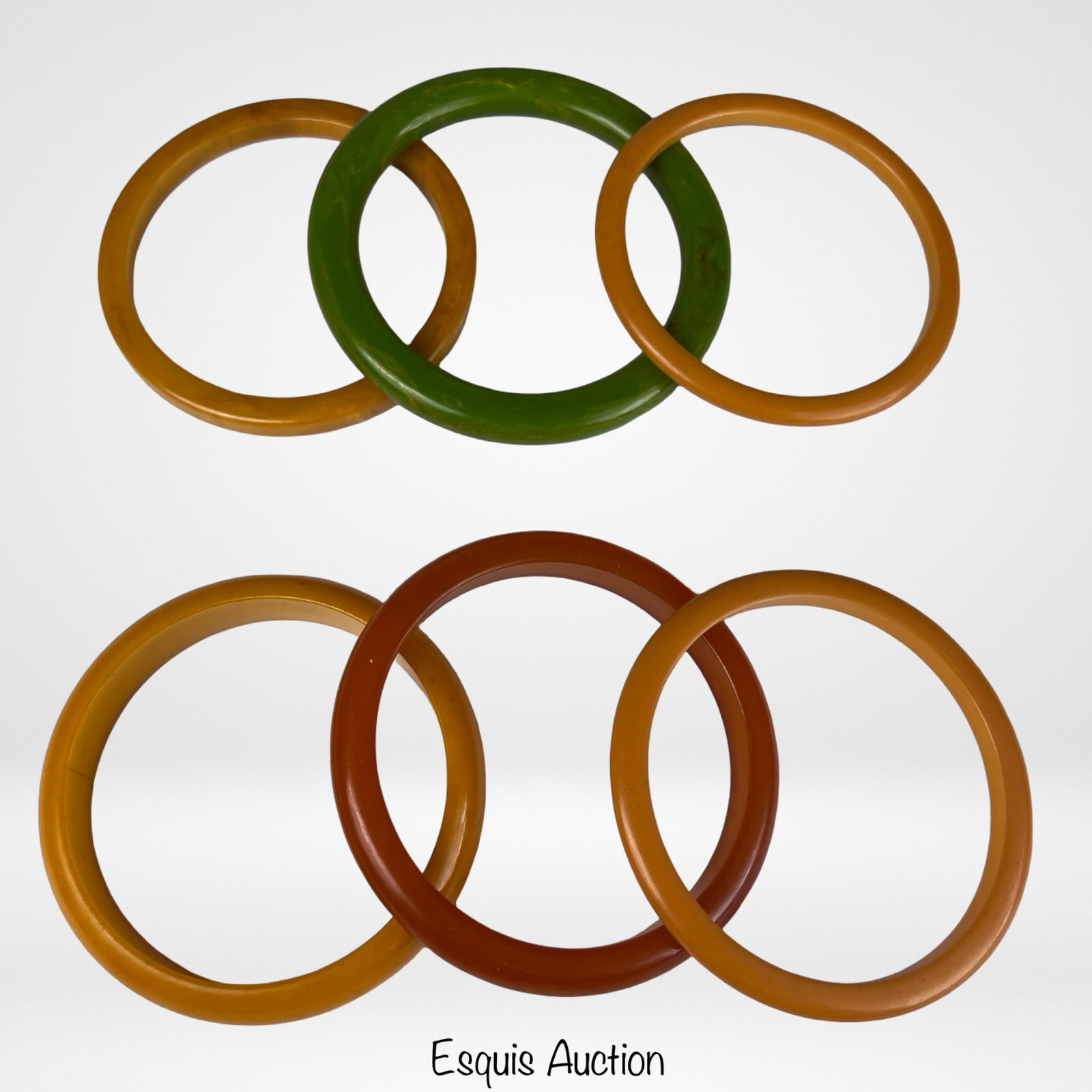 Six Vintage Bakelite Bangle Bracelets: Group of six vintage Bakelite bangle bracelets in warm butterscotch, apple juice amber, and translucent green tones. These classic mid-century bangles display the rich color and smooth polished