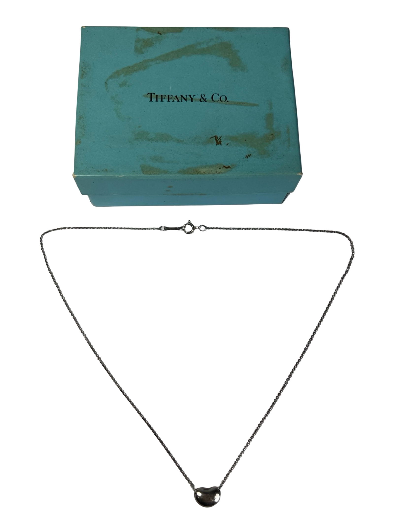 Tiffany & Co Elsa Peretti Sterling Bean Necklace: Elegant Tiffany & Co. sterling silver Bean design pendant necklace created by renowned designer Elsa Peretti. The iconic bean-shaped pendant features a smooth, organic form symbolizing the origin of