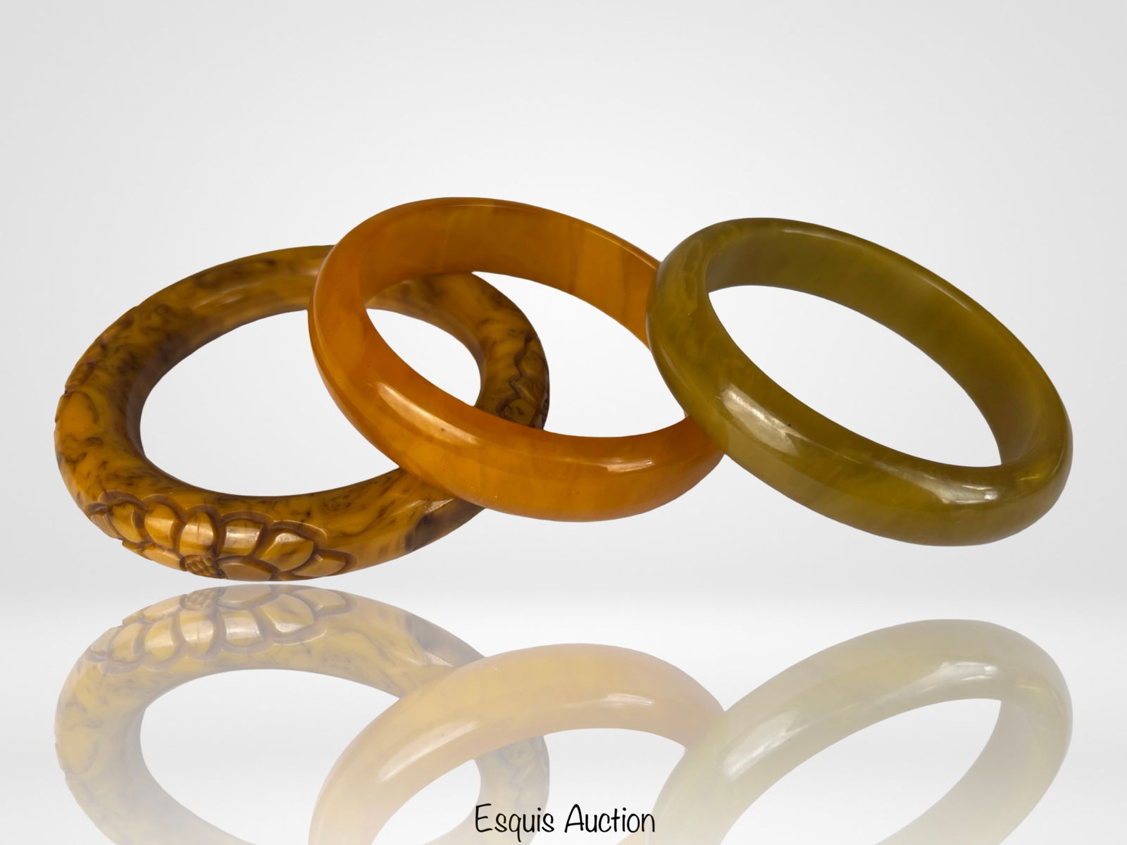 Vintage Bakelite Bangle Bracelets: Appealing group of three vintage Bakelite bangle bracelets showcasing classic mid-century colors and forms. The set includes a deeply carved butterscotch marbled bangle with decorative relief