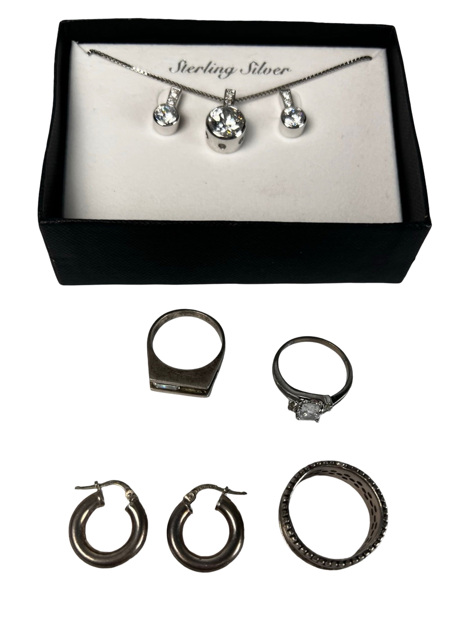 Sterling Silver Jewelry - Rings, Earrings & Neckla: Mixed assortment of sterling silver jewelry including three rings, a pair of hoop earrings, and a coordinated necklace with matching earrings set featuring clear faceted stones. The group includes a