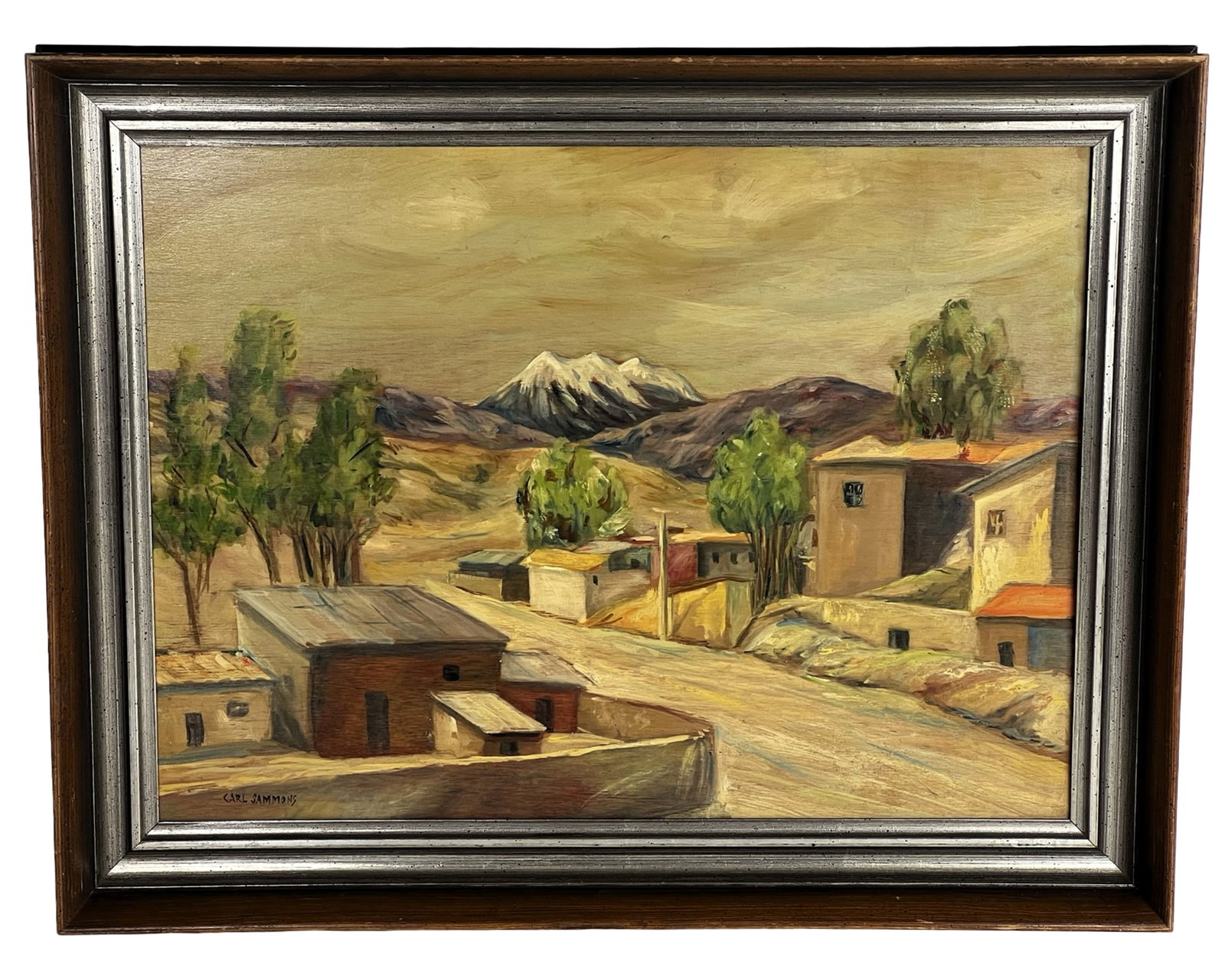Carl Sammons Southwestern Landscape Oil Painting: Expressive oil on board painting depicting a Southwestern village landscape with adobe-style buildings, clustered trees, and a distant snow-capped mountain range. The composition draws the eye along a
