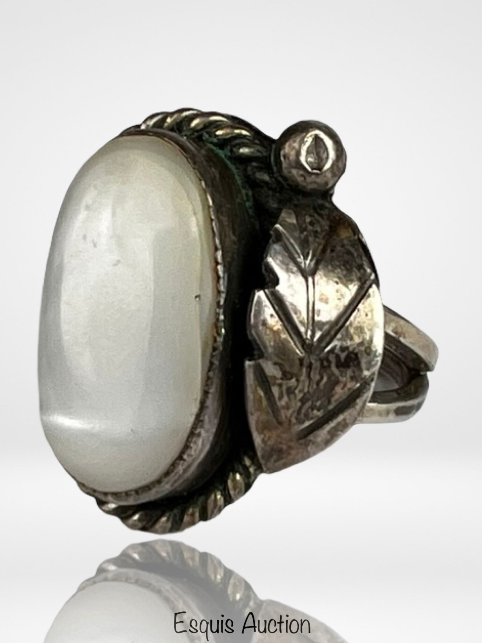 Navajo Sterling Silver Mother of Pearl Ring: Striking Navajo sterling silver ring featuring a large oval mother of pearl cabochon with soft iridescent luster. The stone is set in a substantial bezel and framed by a twisted rope border, adding