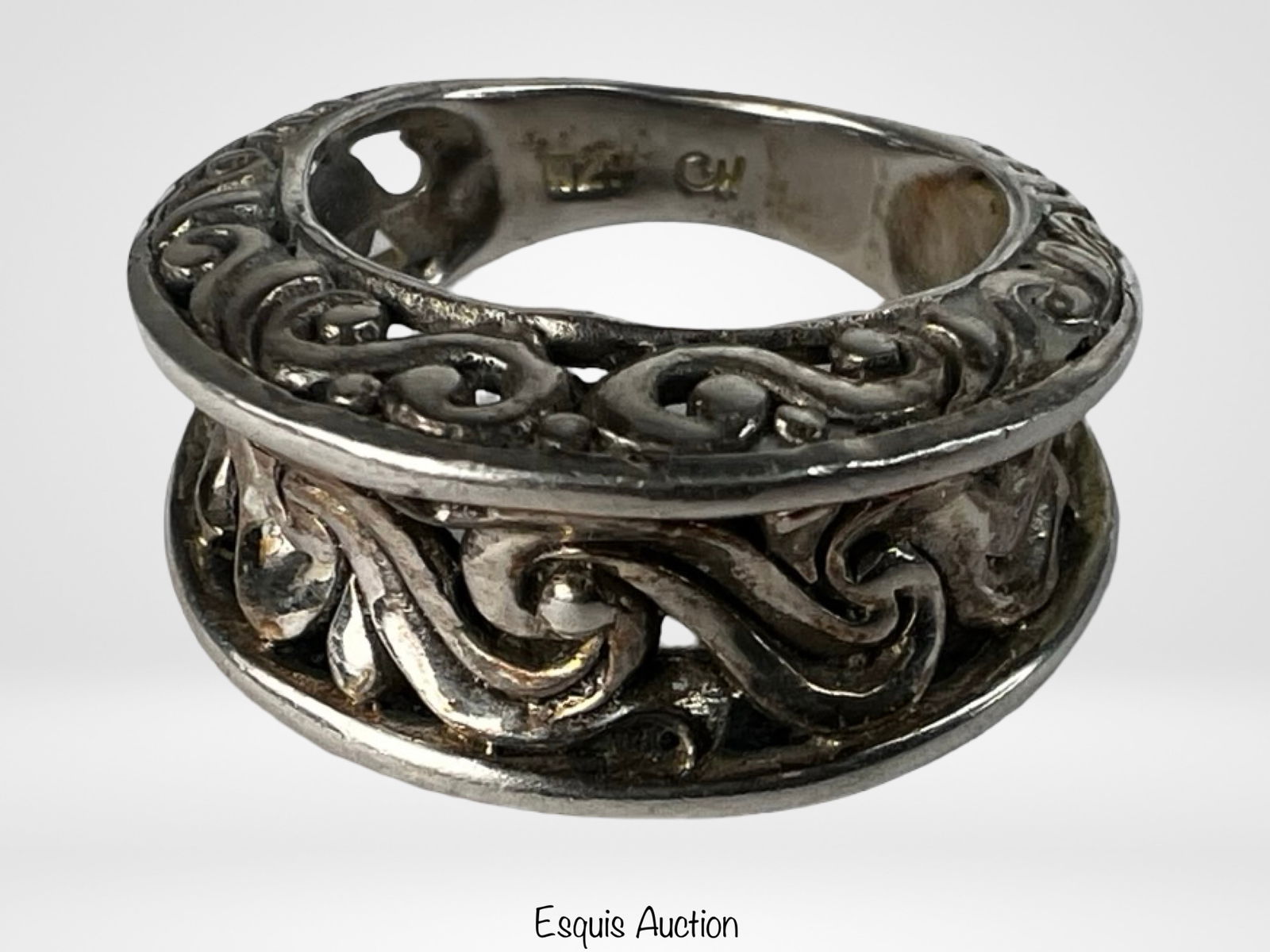 Sterling Silver Openwork Scroll Band Ring: Elegant sterling silver band ring featuring an openwork design with flowing scroll and foliate motifs. The wide, dimensional band is crafted with pierced detailing, creating depth and visual interest