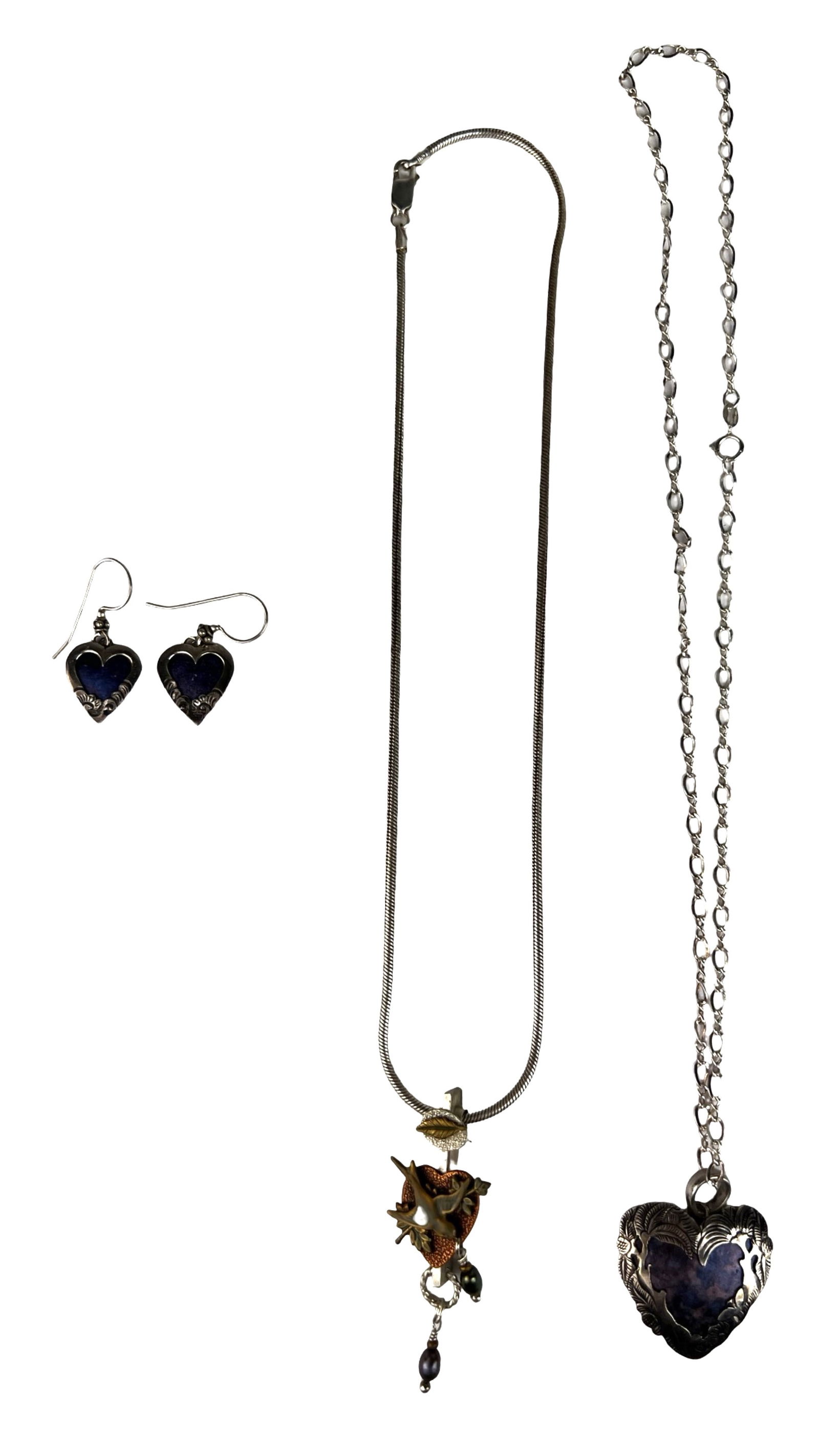 Sterling Silver Necklaces with Matching Earrings: Sterling silver jewelry grouping featuring a heart motif necklace and matching dangle earrings, both set with deep blue inlay and detailed with engraved decorative borders. The set is accompanied by