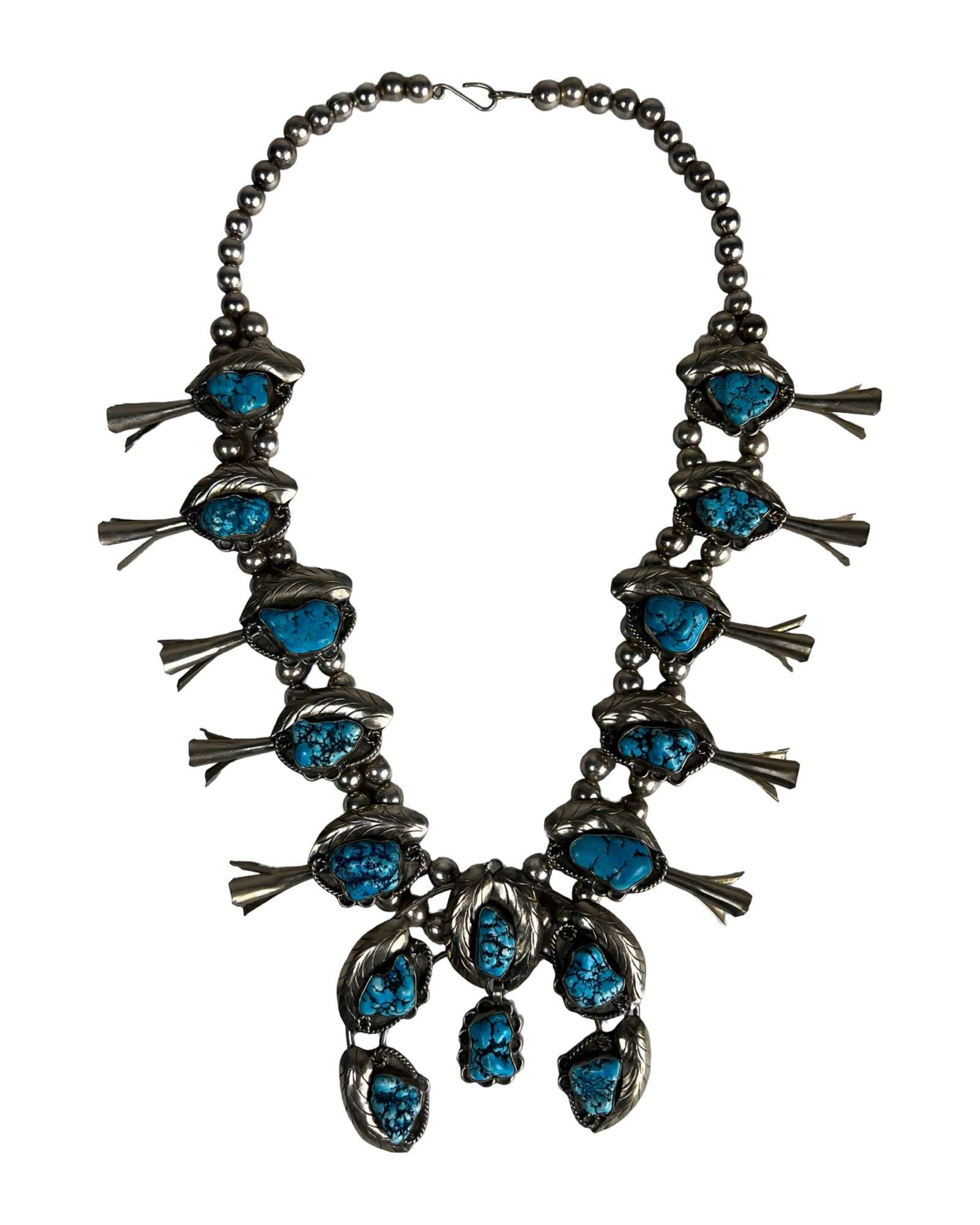 Vintage Native American Squash Blossom Necklace: Bold and visually striking vintage Native American squash blossom necklace featuring an impressive arrangement of polished stones set within traditional leaf and blossom motifs. The necklace is compos