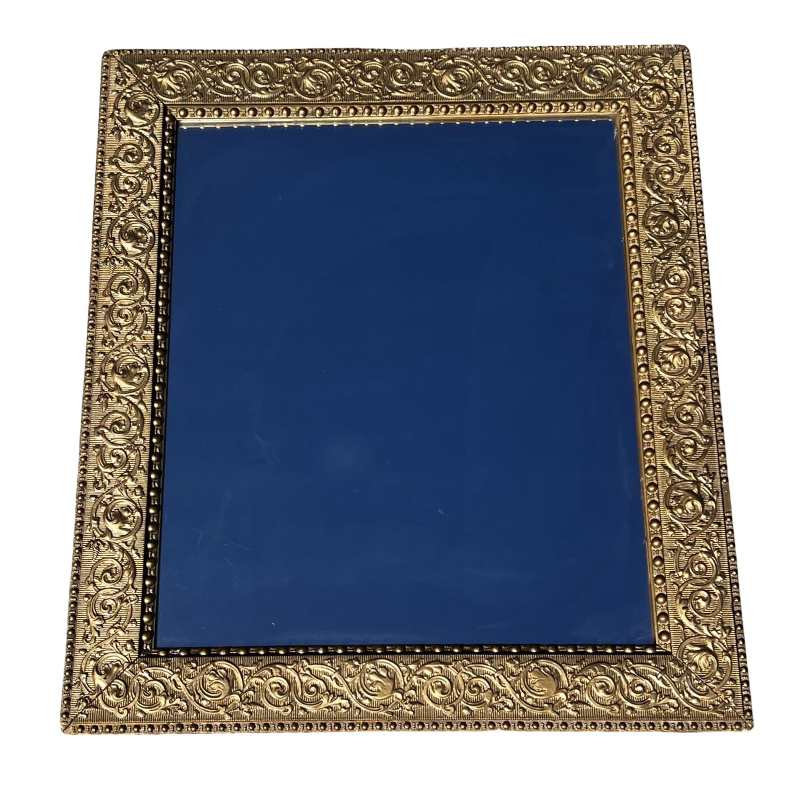 Neoclassical Gilt Wall Mirror Ornate Scrollwork: Neoclassical style gilt wall mirror featuring a richly detailed frame with classical scrolling foliate motifs and beaded inner border. The rectangular form is enhanced by bold relief ornamentation,