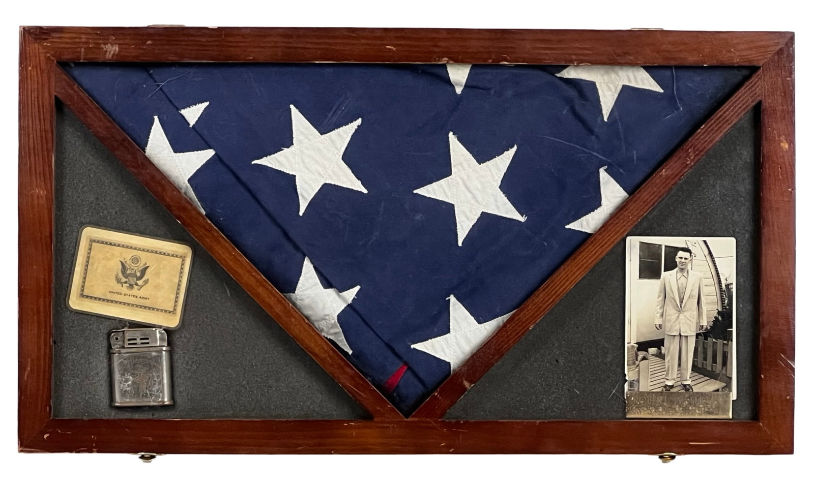 Vietnam War Memorial Shadow Box Folded U.S. Flag: Vietnam War-era memorial shadow box featuring a folded United States flag displayed in a wooden triangular case, accompanied by personal effects and identification items belonging to Robert A. Ehlers