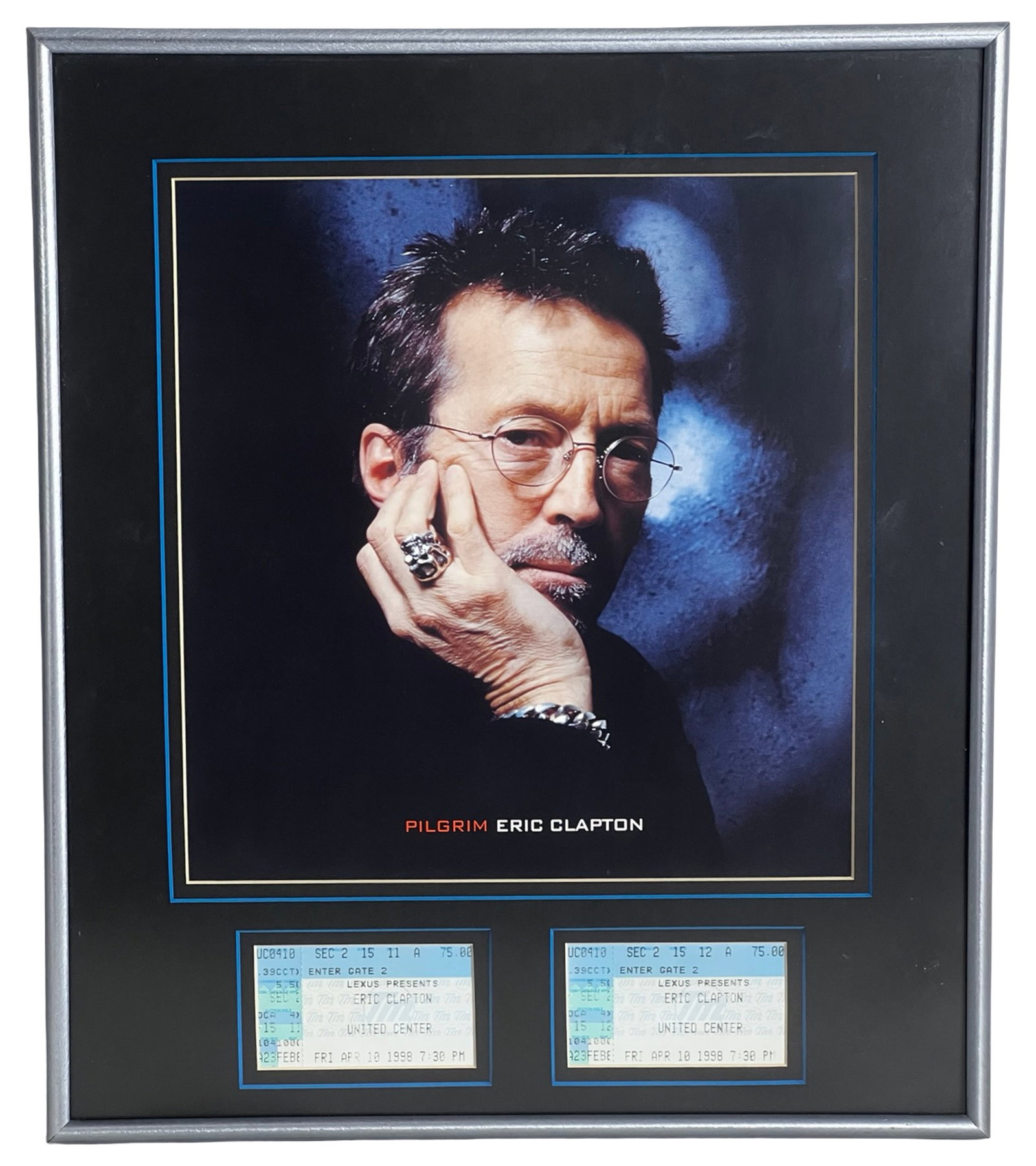 Eric Clapton Ticket Stubs Framed Display: Striking framed concert memorabilia display featuring legendary guitarist and singer Eric Clapton, presented with a portrait image from his Pilgrim era (circa late 1990s). The composition is paired