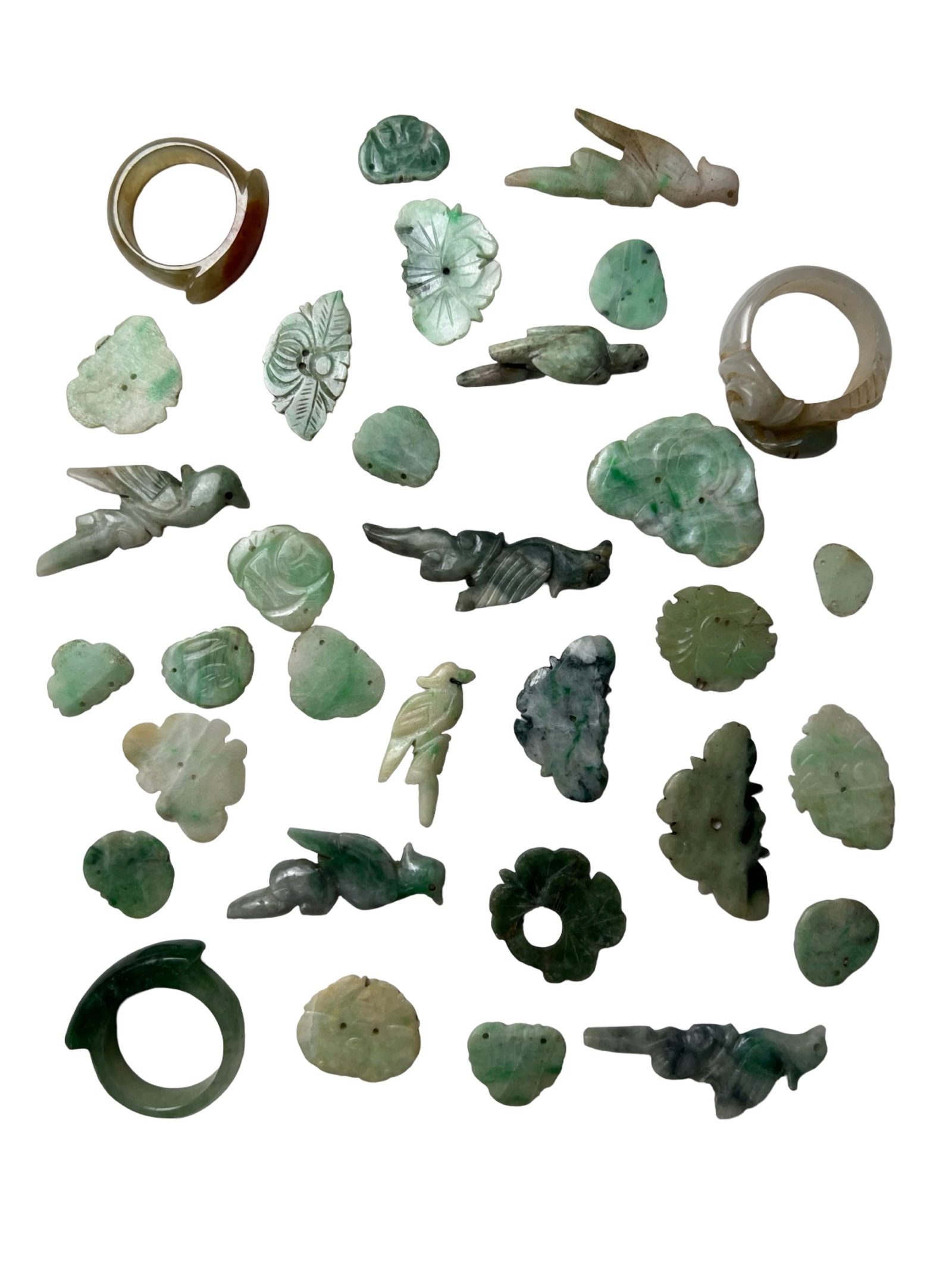 Qing Dynasty Jade Carvings Hat Ornaments & Rings: Collection of antique jade carvings including Qing Dynasty style hat ornaments, carved pendants, and figural pieces. The group features a variety of motifs such as birds, leaves, and floral forms, exe