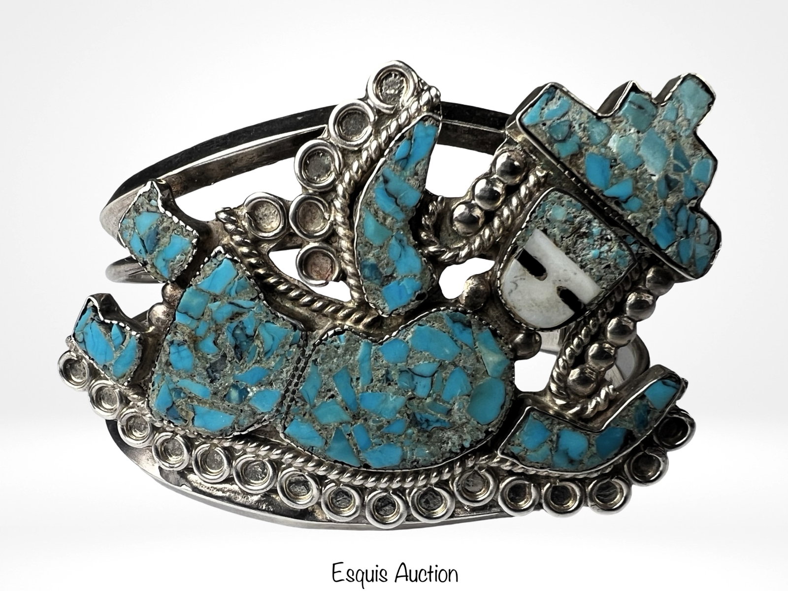 Massive Sterling Silver Turquoise Cuff Bracelet: Large and impressive sterling silver cuff bracelet featuring turquoise chip inlay in a bold geometric and figural design. The bracelet displays a central stylized figure surrounded by mosaic